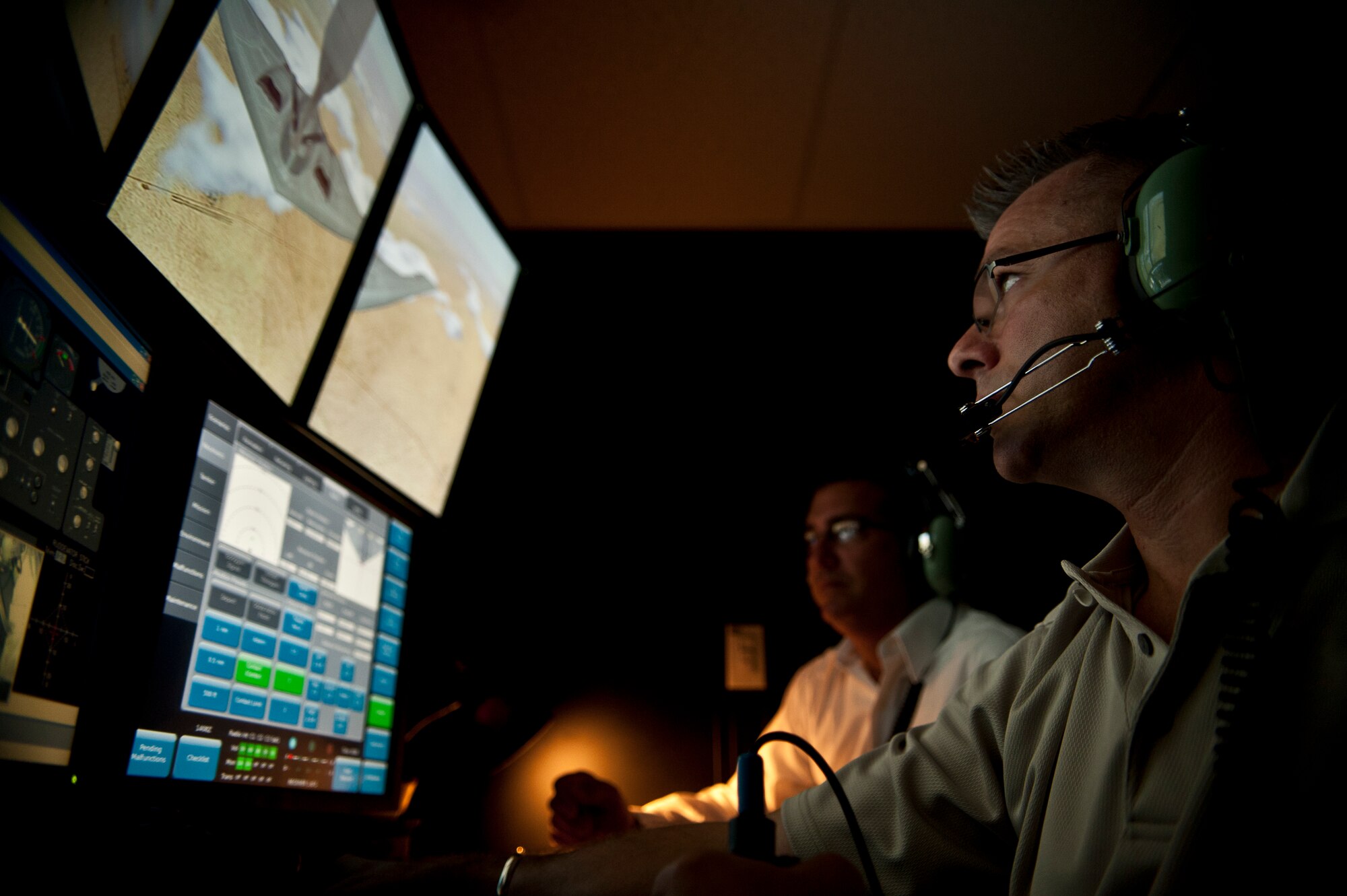 John Mercer, CAE USA boom operator instructor, monitors a trainee's mission progress on the new KC-135 Boom Operator Weapon System Trainer July 12, 2013 at MacDill Air Force Base, Fla. The BOWST will allow boom operators to experience refueling missions that they might not encounter during day to day operations, including emergencies. (U.S. Air Force photo by Airman 1st Class Sarah Breer/Released)(Cropped)