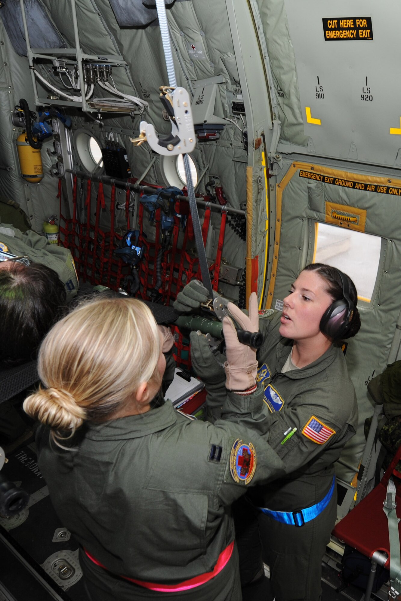 Senior Airman Rae Kincade, an aeromedical evacuation crewmember with the 36th AES, works with Capt. Mackenzie Johnson, a 36th AES flight nurse, to fasten a patient-laden litter into support stanchions on a Royal Canadian Air Force C-130J medium transport aircraft on Pope Field, N.C., on July 12, 2013.  The 36th AES is training with Canadian medical counterparts and members of the 43rd AES during a two-day exercise intended to enhance inter-service partnership and provide continuation training.  (Air Force Photo by Tech. Sgt. Peter R. Miller)