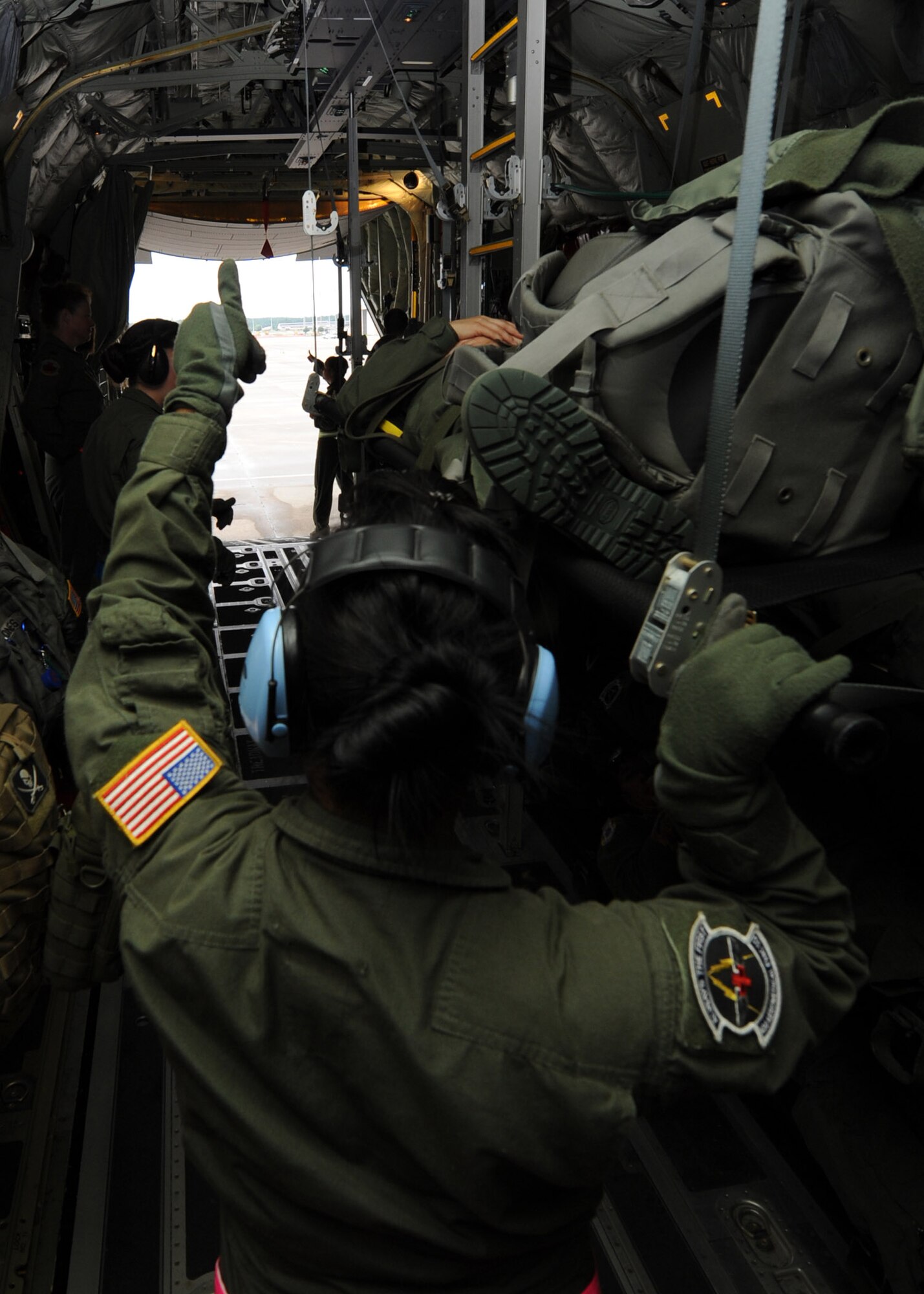 Staff Sgt. Kelsiann Echavaria, an aeromedical evacuation crewmember with the 43rd AES, gives the “thumbs up” to Capt. Tiffany Hubbard, a 43rd AES flight nurse, on a Royal Canadian Air Force C-130J at Pope Field, N.C., on July 12, 2013.  AE crewmembers use hand-and-arm signals to communicate within aircraft due to the deafening engine noise, and the “thumbs up” signal indicates to awaiting litter-bearers that the crew is ready to receive another patient.  (Air Force Photo by Tech. Sgt. Peter R. Miller)