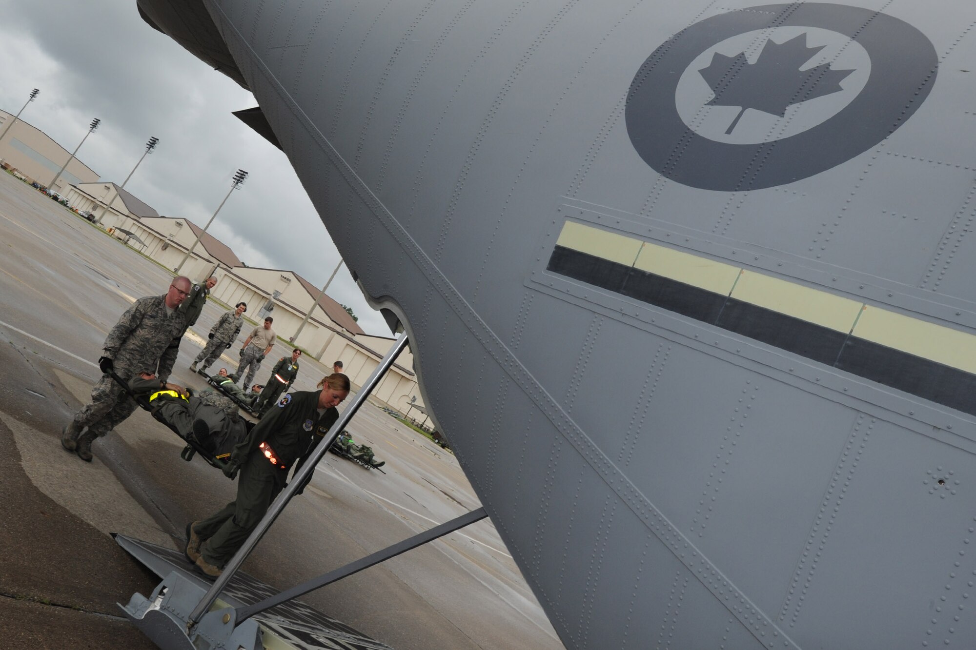 2nd Lt. Ben Kifer (rear litter bearer), the 43rd Aeromedical Evacuation (AE) Squadron operations officer, and Staff Sgt. Shaun Moore, a 43rd AE technician, carry a patient-laden litter into a Royal Canadian Air Force C-130J medium transport aircraft during a training exercise at Pope Field, N.C., on July 12, 2013.  The 43rd AES is training alongside Canadian medical counterparts and members of the 36th AES for a two-day exercise intended to enhance inter-service partnership and provide continuation training.  (Air Force Photo by Tech. Sgt. Peter R. Miller)