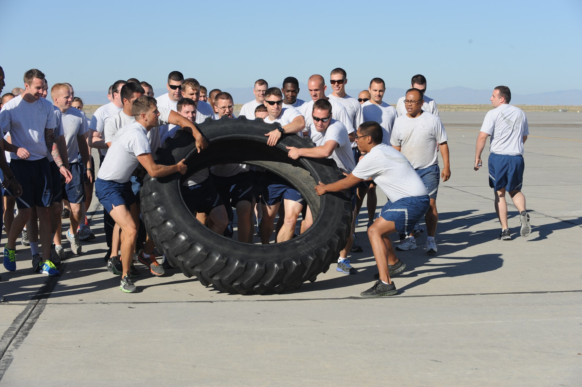A team races during the tire flipping portion of the Gunfighter Challenge July 11, 2013, at Mountain Home Air Force Base, Idaho. Members of both teams took turns flipping a tire to the finish line. (U.S Air Force photo by Airman 1st Class Malissa Lott/Released)
