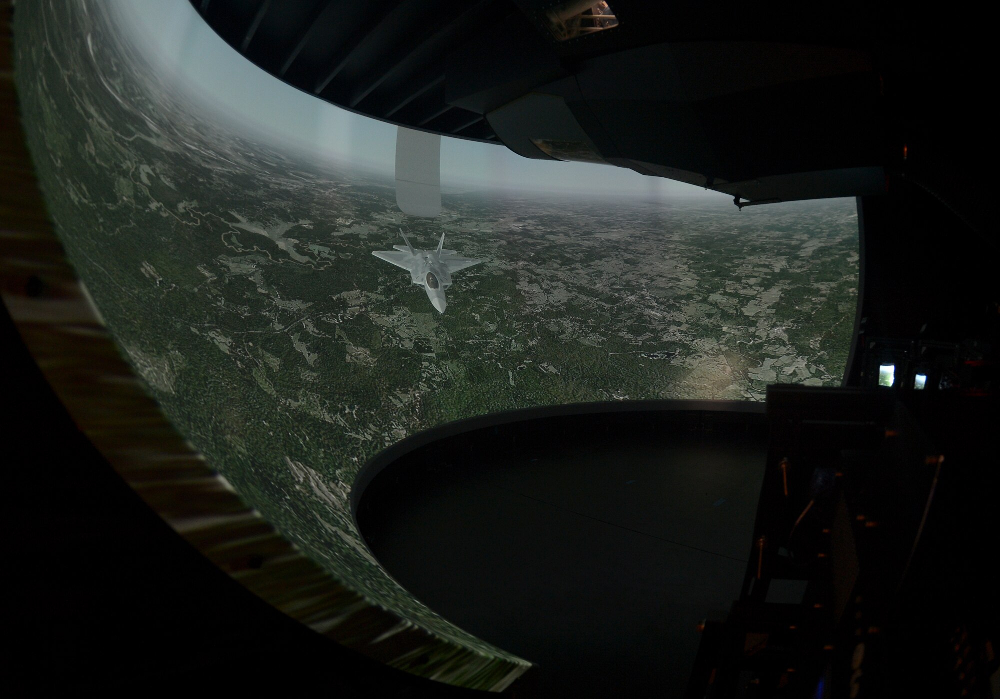 The KC-135 Stratotanker Boom Operator Weapon System Trainer uses a series of laser aligned projected images that incorporate state of the art technology to depict locations through latitude and longitudinal coordinate inputs. Boom operators that are training in the simulator lay belly down and peer through a viewing window just as they do in the actual aircraft. (U.S. Air Force Photo by Staff Sgt. Brandon Shapiro/Released.)  