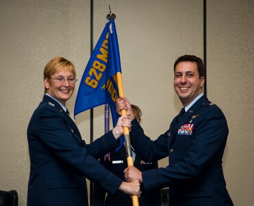 (Left) Col. Judith Hughes, 628th Medical Group commander, passes the 628th Medical Operations Squadron guidon to Lt. Col. Luis Otero during the 628th MDOS Change of Command, June 27, 2013 at Joint Base Charleston – Air Base, S.C. Otero replaced Col. Susan Moran. (U.S. Air Force photo/Senior Airman Dennis Sloan)