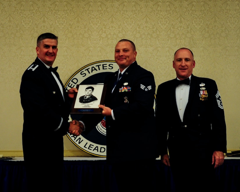 Col. Al Miller, 437th Airlift Wing deputy commander, and Chief Master Sgt. Earl Hannon, 628th Air Base Wing command chief, present Senior Airman Kyle Roman, 628th Security Forces Squadron installation patrolman, the John Levitow Award during the Airman Leadership School Class 13-E graduation ceremony June 27, 2013, at JB Charleston - Air Base, S.C. The Levitow Award is awarded for a student's exemplary demonstration of excellence, both as a leader and scholar. (U.S. Air Force photo/Senior Airman Dennis Sloan)