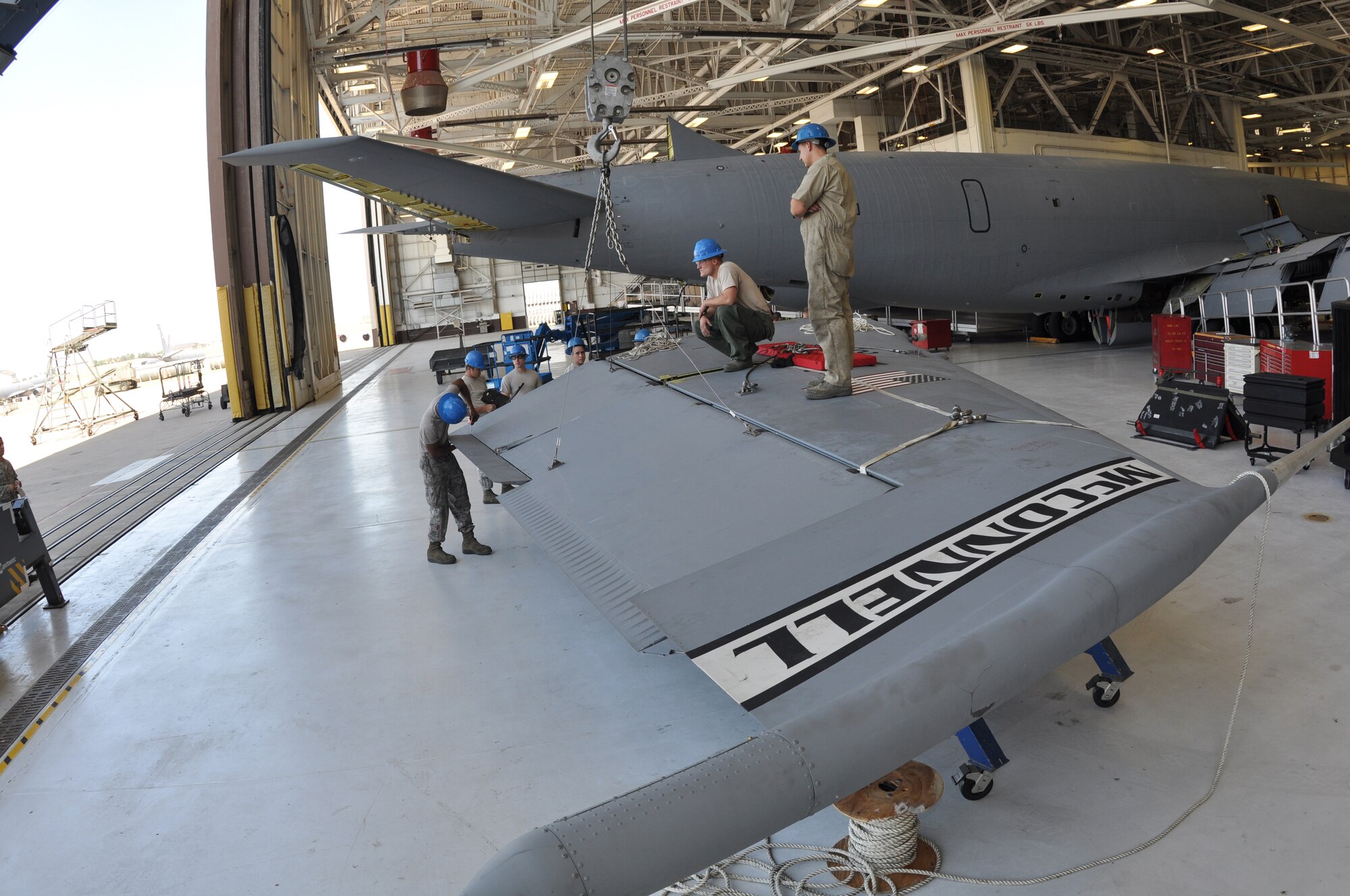 A total force initiative team of crew chiefs from the Repair and Reclamation sections of the 22nd Maintenance Squadron and 931st Maintenance Squadron repair the rear vertical stabilizer of a KC-135 Stratotanker at McConnell AFB, Kan., July 12. (Air Force Photo by Airman 1st Class Jose Leon) 