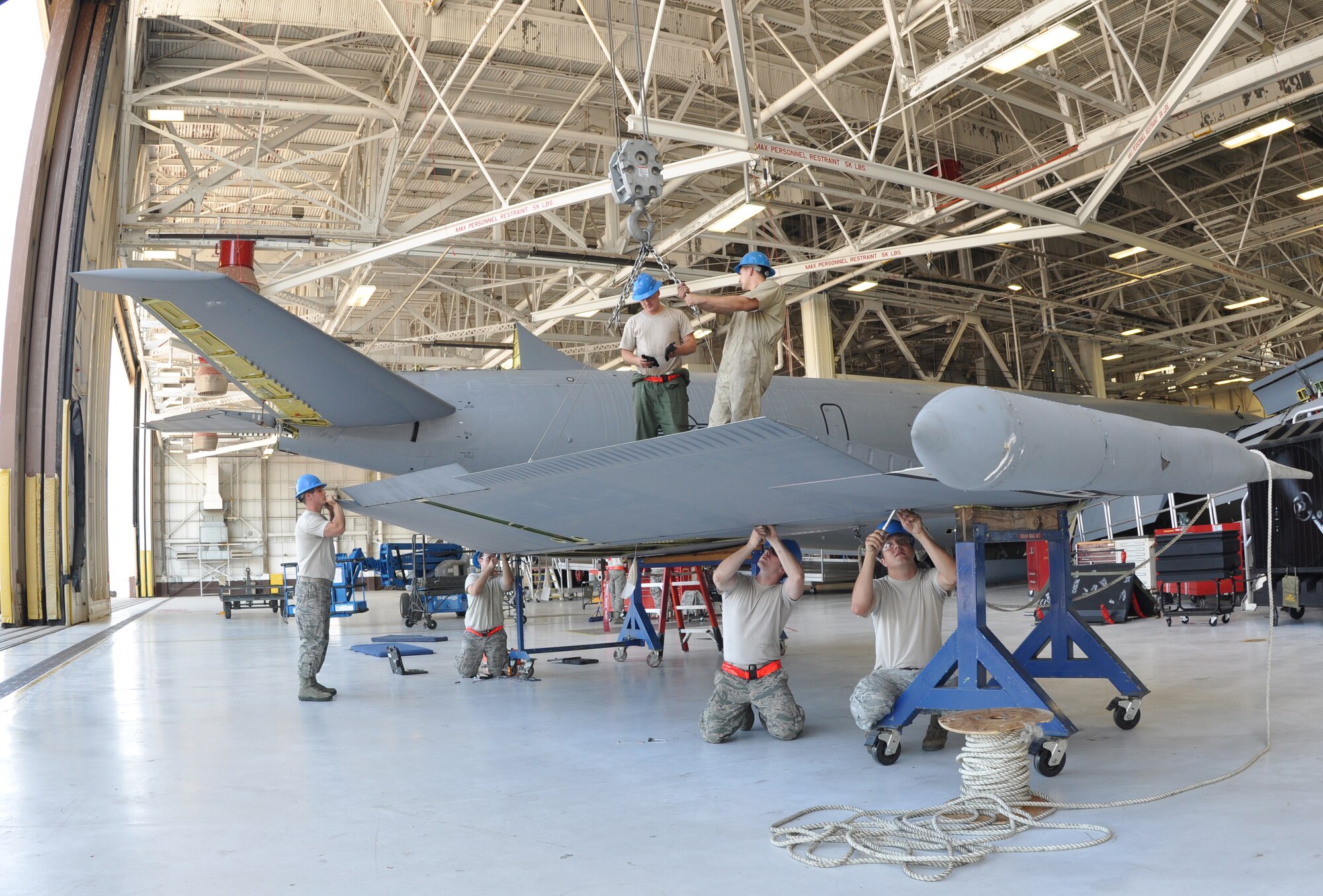 A total force initiative team of crew chiefs from the Repair and Reclamation sections of the 22nd Maintenance Squadron and 931st Maintenance Squadron repair the rear vertical stabilizer of a KC-135 Stratotanker at McConnell AFB, Kan., July 12. (Air Force Photo by Airman 1st Class Jose Leon) 