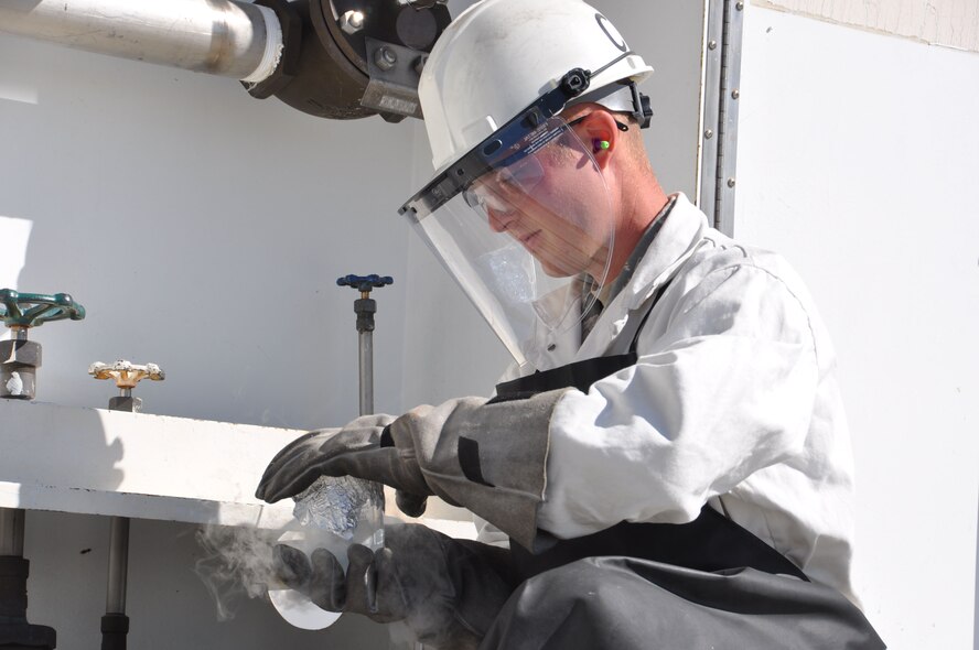 Airman 1st Class Travis Allred, 60th Logistics Readiness Squadron fuels cryogenics technician, collects a sample of liquid oxygen at building 352, July 10, 2013. Allred samples the liquid oxygen to check for contaminants and odors that may be harmful for fliers. (U.S. Air Force photo/Staff Sgt. Christopher Carranza)