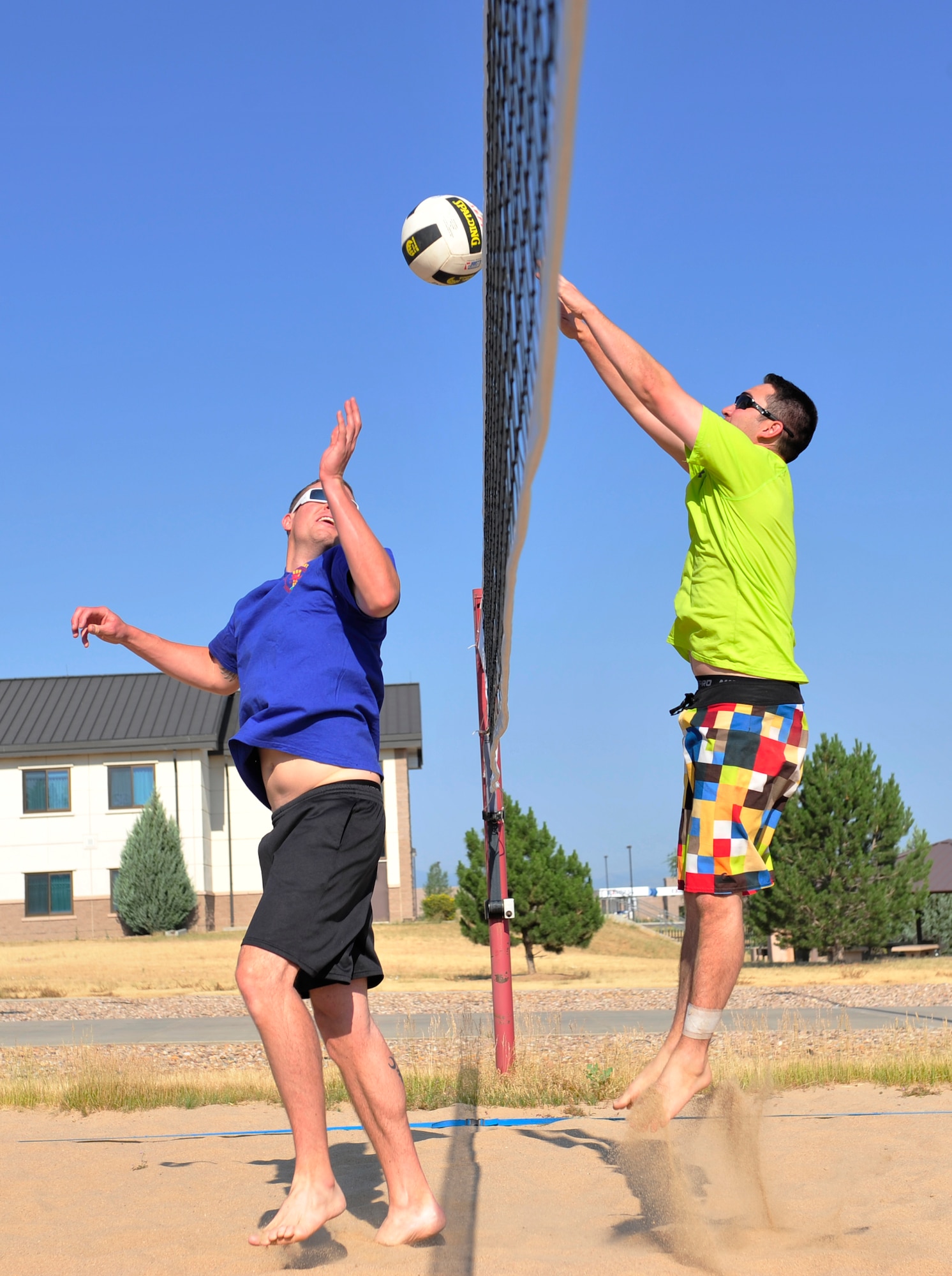 Joseph Hennigan, 460th Operations Support Squadron, right, blocks a hit from Mathew Holley, 460th OSS, during the annual four-on-four sand volleyball tournament July 11, 2013, at Buckley Air Force Base, Colo. Hennigan scored half of the team’s points and continuously cheered on his teammates. (U.S. Air Force photo by Airman 1st Class Darryl Bolden Jr./Released)