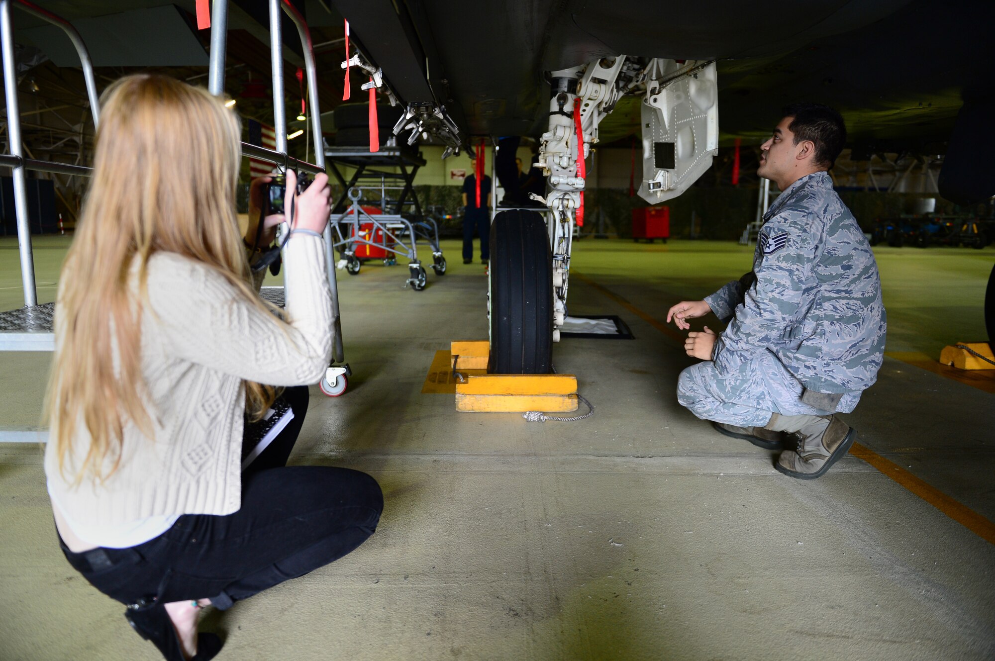 ROYAL AIR FORCE LAKENHEATH, England — Elizabeth Ritsema, 48th Fighter Wing Public Affairs intern, takes photos of Staff Sgt. Erick Ballesteros, 48th Equipment Maintenance Squadron Repair and Reclamation craftsman, as part of a work experience program July 2, 2013. Ritsema’s work experience program is mandatory for all British school system year 10 (9th grade) students. (U.S. Air Force photo by Senior Airman Lausanne Genuino)