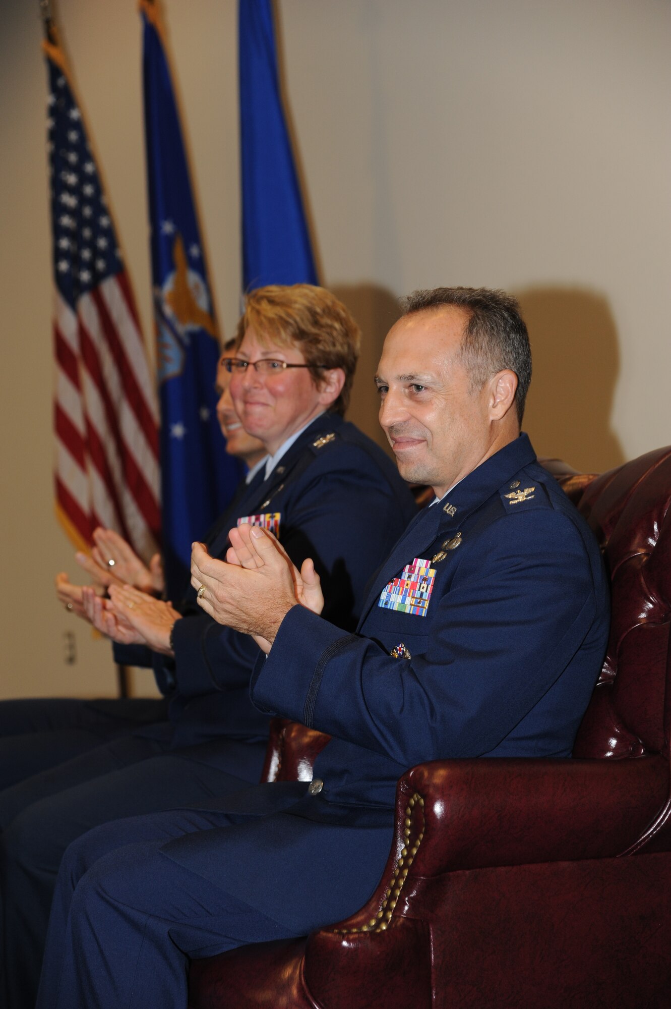 Col. Maureen Smith, outgoing 81st Training Group commander, and Col. George Tombe, incoming 81st TRG commander, applaud as introductions were made during the 81st TRG change of command ceremony July 11, 2013, at the Roberts Consolidated Aircraft Maintenance Facility, Keesler Air Force Base, Miss.   Brig. Gen. Brad Spacy, 81st Training Wing commander, was the officiating officer for the event.