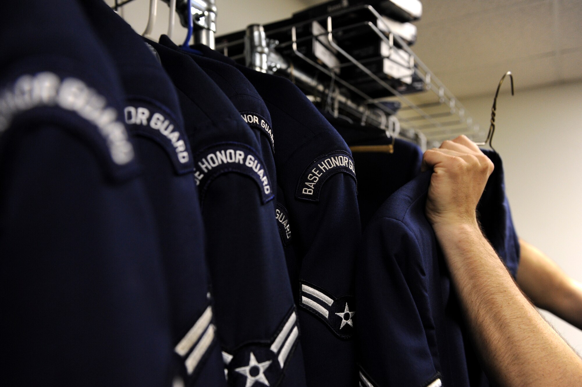 Senior Airman Jonathan Owen, a Base Honor Guard ceremonial guardsman, removes an aiguillette from a ceremonial jacket May 28, 2013, at Little Rock Air Force Base, Ark. One of Owen's additional duties while in the honor guard is ensuring that the ceremonial uniforms are serviceable and meet dress and appearance standards. (U.S. Air Force photo by Senior Airman Rusty Frank)