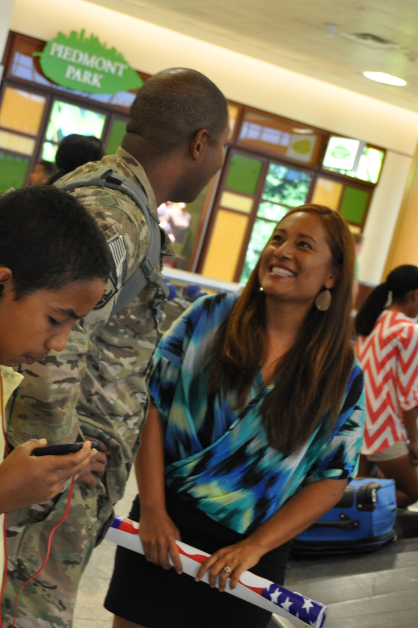 Maj. Quincy Hudson, 94th Airlift Wing protocol officer, is welcomed home from a six-month deployment at Hartsfield-Jackson International Airport by his wife, Naomi, July 11. Hudson served as the personnel officer for Camp Phoenix, Kabul, Afghanistan. (U.S. Air Force photo/James Branch)