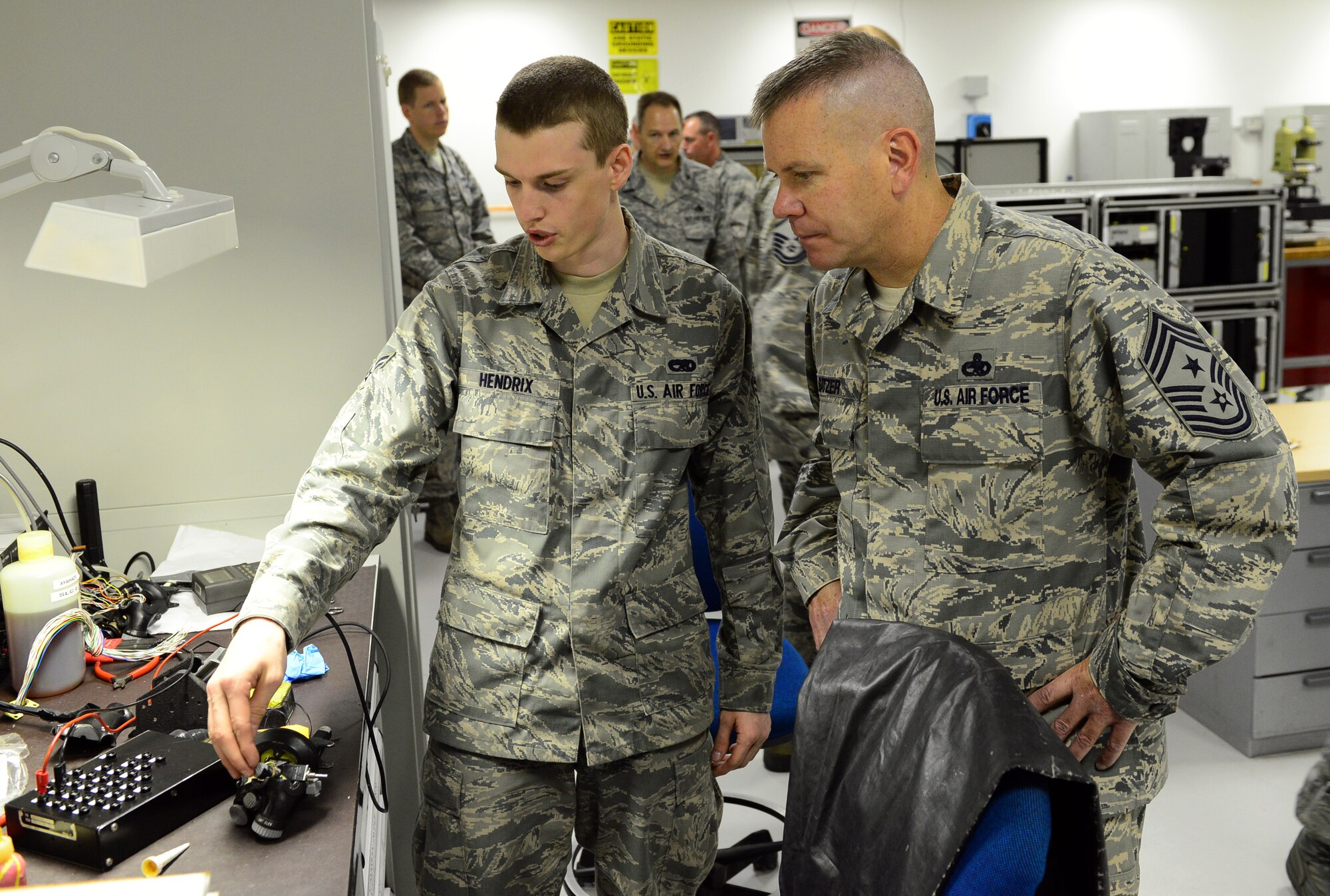 (From left) Airman 1st Class Brandon Hendrix, 31st Maintenance Squadron avionics technician, explains his job to Chief Master Sgt. Mark Batzer, 31st Fighter Wing command chief, July 2, 2013, at Aviano Air Base, Italy. As command chief, Batzer serves as the advisor to the commander on matters involving over 3,500 active duty enlisted personnel. (U.S. Air Force photo/Airman 1st Class Matthew Lotz)