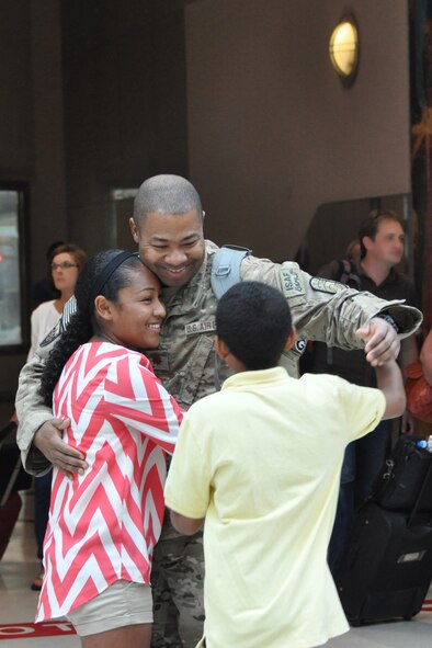 Maj. Quincy Hudson, 94th Airlift Wing protocol officer, is welcomed home from a six-month deployment at Hartsfield-Jackson International Airport by his two children July 11. Hudson served as the personnel officer for Camp Phoenix, Kabul, Afghanistan. (U.S. Air Force photo/James Branch)