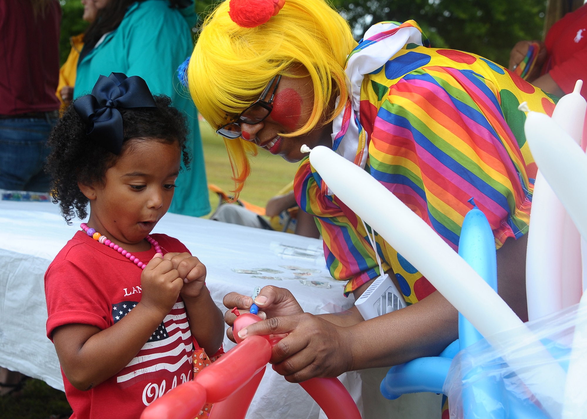 Javalen Perrio looks on as DD the clown makes her a balloon animal at the Fireworks on the Water event July 4 at the Stennis Lock and Dam. Children’s activities started at 4:30 p.m. and included face-painting, bouncy houses, and DD the clown. (U.S. Air Force Photo/ Airman 1st Class Stephanie Englar)
