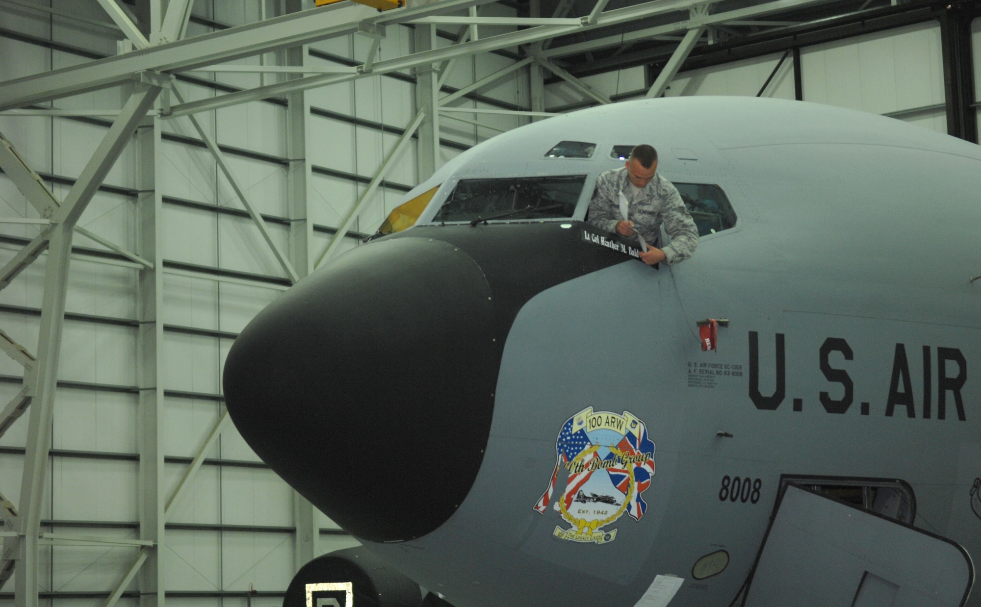 Staff Sgt. Joseph Weese, 100th Maintenance Squadron KC-135 crew chief from Port Charlotte, Fla., unveils Lt. Col Heather Baldwin’s, 100th Operations Support Squadron commander, name plate on a KC-135 during the 100th OSS change of command July 12, 2013, in Hanger 814 on RAF Mildenhall, England. It is a tradition to reveal the name of the incoming commander on an aircraft during a change of command ceremony. (U.S. Air Force photo by Airman 1st Class Dillon Johnston/Released) 