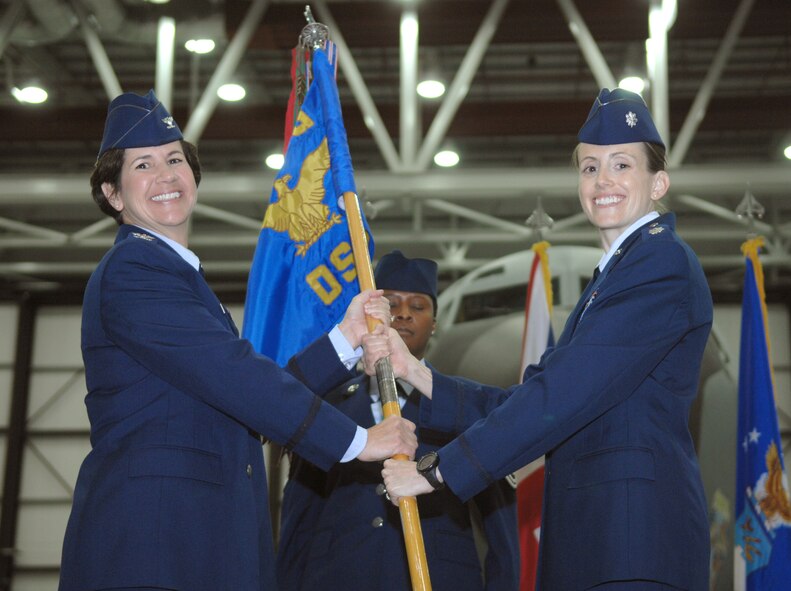 From right, Lt. Col. Heather Baldwin, 100th Operations Support Squadron commander, receives the 100th OSS guidon from Col. Nancy Bozzer, 100th Operations Group commander, during the 100th OSS change of command July 12, 2013, in Hanger 814 on RAF Mildenhall, England. Baldwin was previously the 100th Air Refueling Wing chief of safety. (U.S. Air Force photo by Airman 1st Class Dillon Johnston/Released)