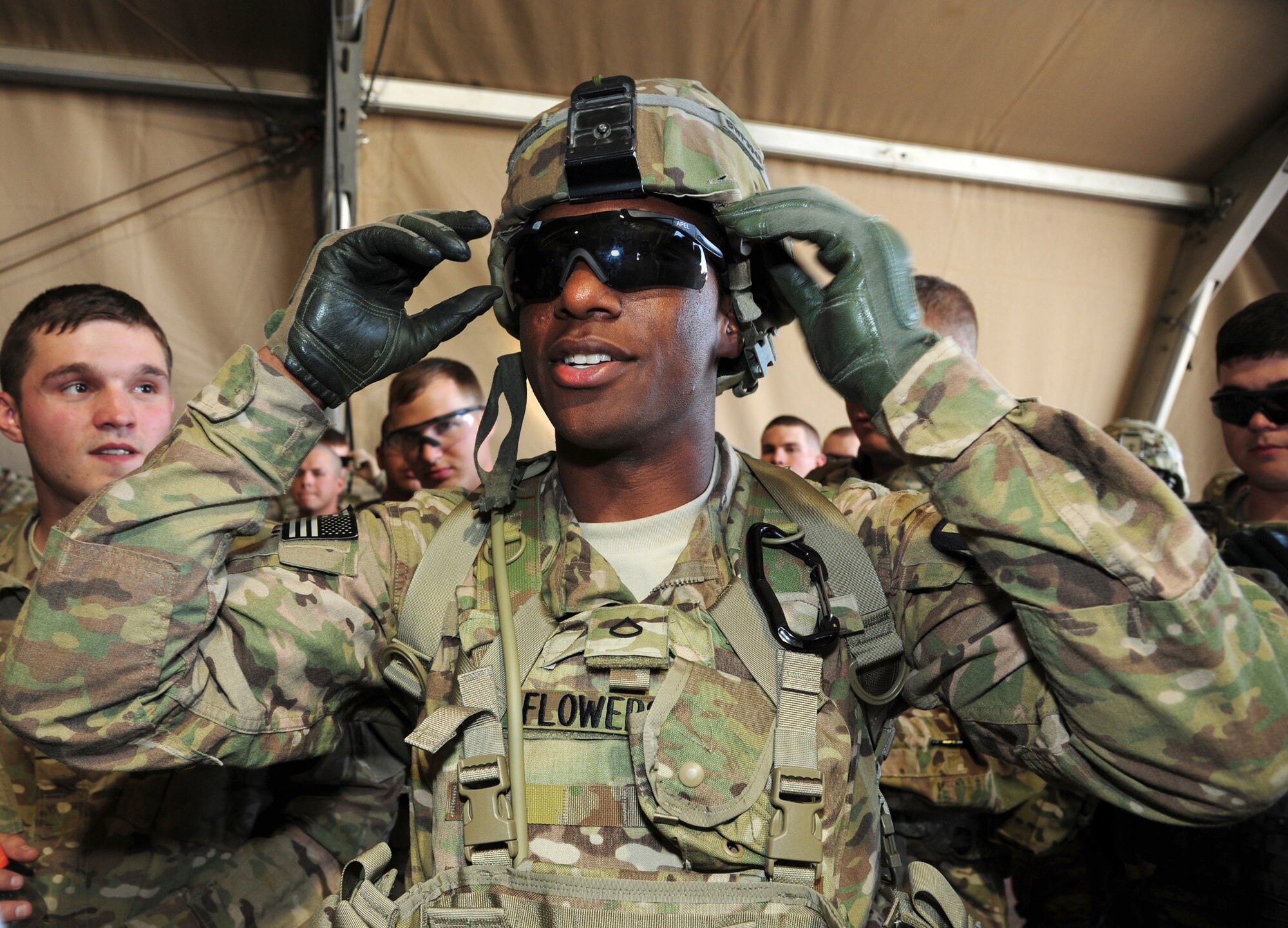 U.S. Army Pfc. Devante Flowers, Bravo Company, 1st Brigade, 5th Calvary Division, gears up prior to entering a Mine Resistant Ambush Protected vehicle rollover simulator at Transit Center at Manas, Kyrgyzstan, July 4, 2013. Flowers, is deployed from Fort Hood, Texas, and was the 100,000th service member trained in MRAP rollover egress by the Joint Readiness Staging Onward Movement and Integration unit at TCM. (U.S. Air Force photo/Staff Sgt. Krystie Martinez)