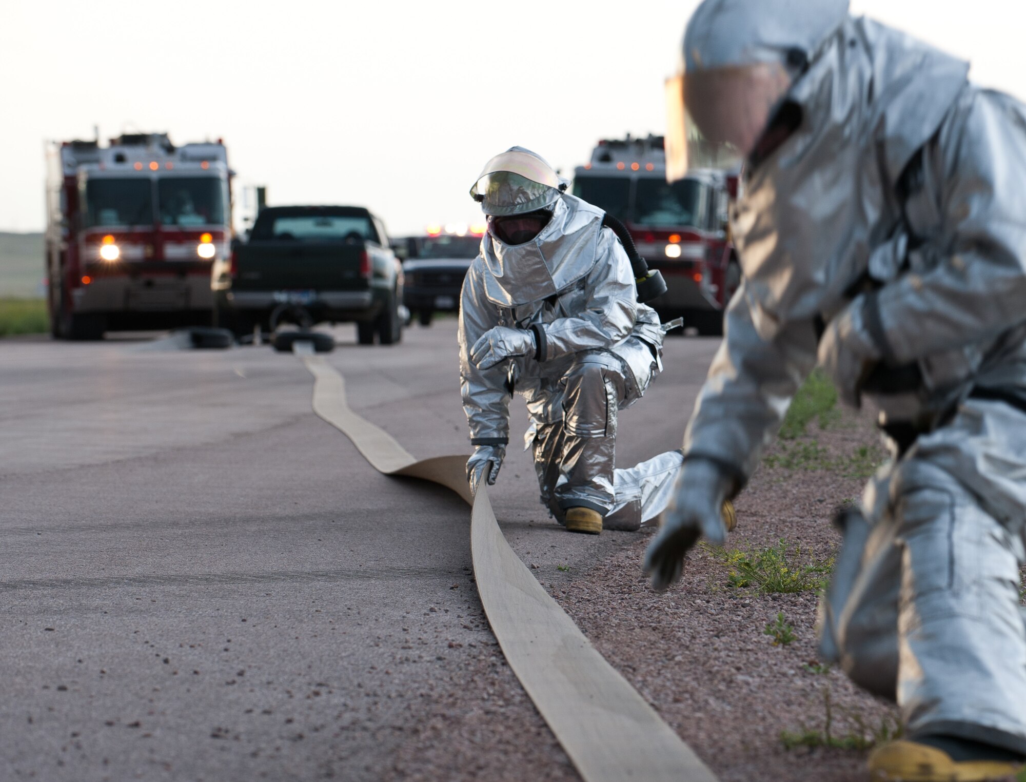 Members of the 28th Civil Engineer Squadron Fire Department align the tape of a mobile aircraft arresting system during a phase II operational readiness exercise at Ellsworth Air Force Base, S.D., July 11, 2013. The purpose of the MAAS is to provide a mobile catch system for aircraft in permanent or temporary environments, ensuring aircraft are able to land in any situation. (U.S. Air Force photo by Airman 1st Class Alystria Maurer/Released)