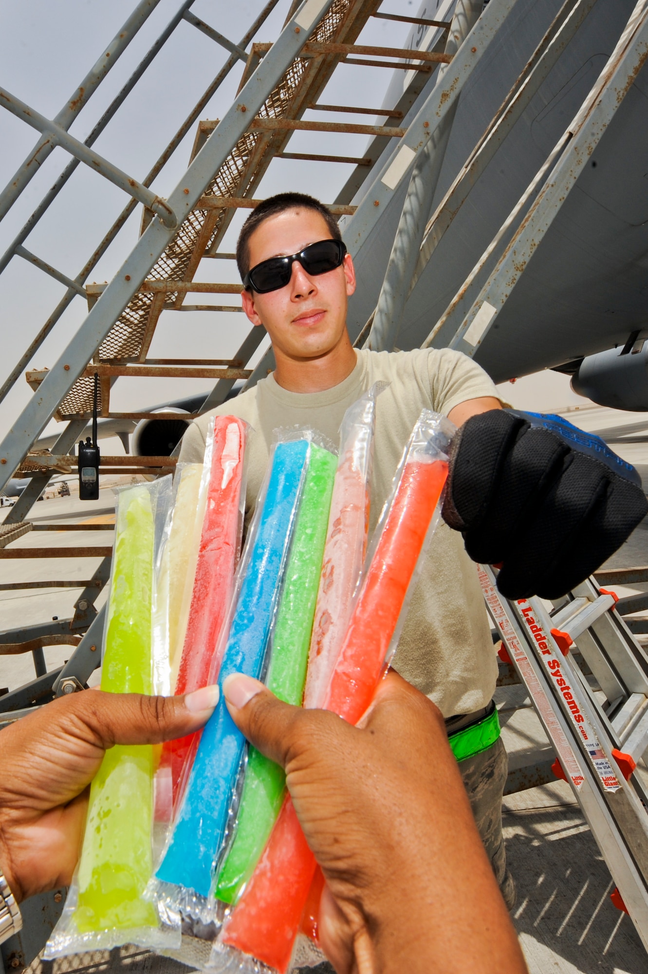 U.S. Air Force Airman 1st Class Dylan Figg, 380th Expeditionary Aircraft Maintenance Squadron KC-10 Extender maintainer, reaches for an icy pop on a disclosed location in Southwest Asia July 9, 2013. Icy pops are handed out by U.S. Air Force Chaplain (Capt.) Winston Jones, 380th Air Expeditionary Wing, on a weekly basis to maintainers working out on the line. Figg is native to Fontana, Calif., and is deployed from Joint Base McGuire-Dix-Lakehurst, N.J. (U.S. Air Force photo by Staff Sgt. Joshua J. Garcia) 