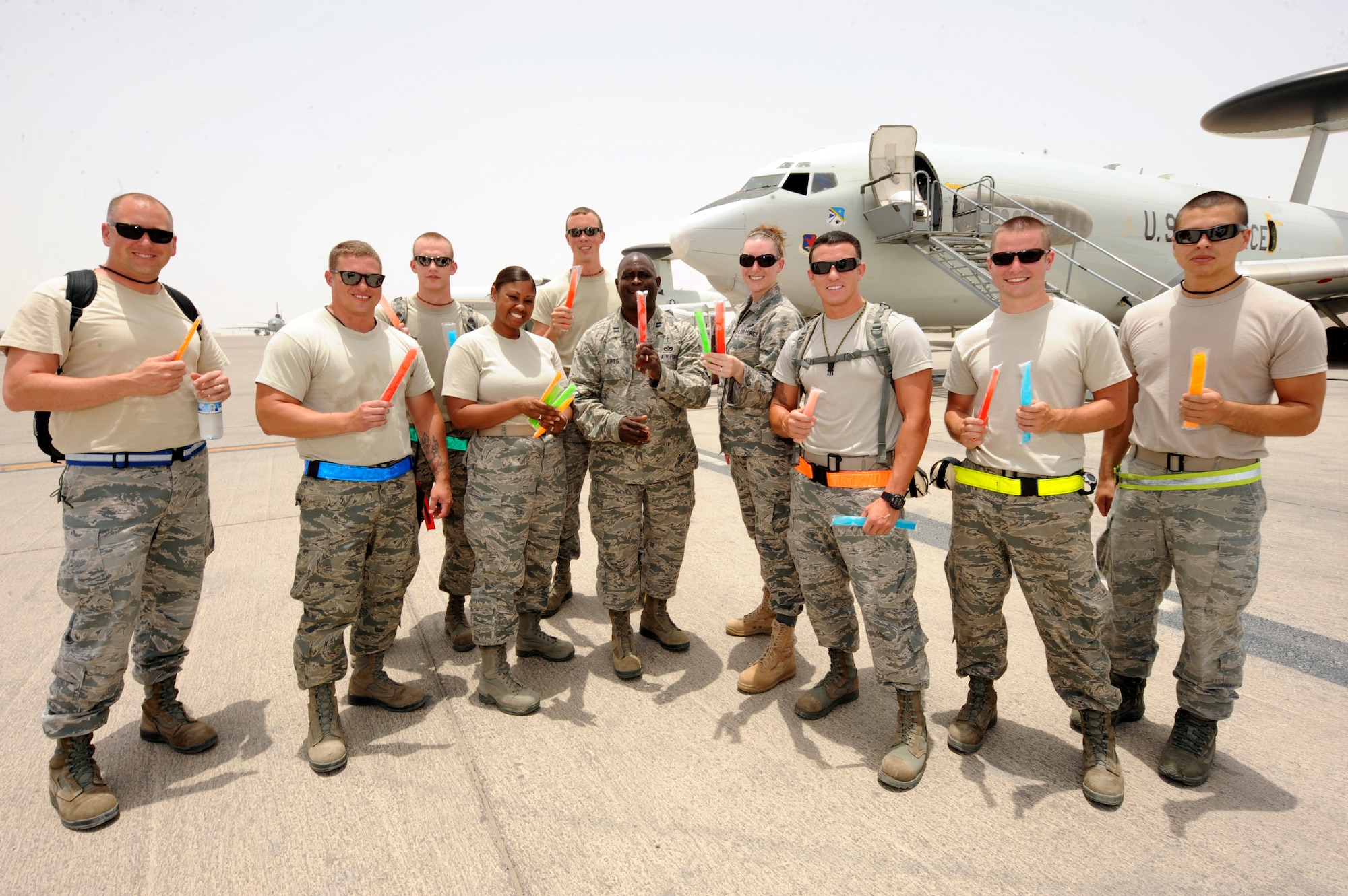 Airmen from the 380th Expeditionary Maintenance Group pose with U.S. Air Force Chaplain (Capt) Winston Jones, center, 380th Air Expeditionary Wing, during a flightline visit at an undisclosed location in Southwest Asia July 9, 2013. Jones visits the flightline bringing ice pops and water to maintainers working on the line weekly. (U.S. Air Force photo by Staff Sgt. Joshua J. Garcia)