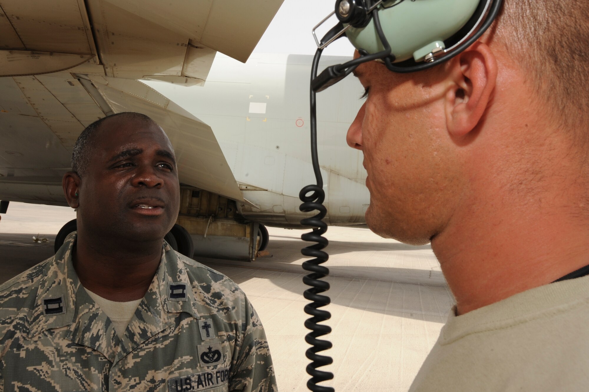 U.S. Air Force Chaplain (Capt.) Winston Jones, 380th Air Expeditionary Wing, talks with U.S. Air Force Staff Sgt. Jason Lewis, 380th Expeditionary Aircraft Maintenance Squadron E-3 Sentry fuel cell maintainer, during a visit to the flightline at an undisclosed location in Southwest Asia July 9, 2013. Jones delivers icy pops to maintainers on the flightline every week, he uses this as an opportunity to talk to the Airmen about any issues they may have. Jones hails from Detroit, Mich., and is deployed from Joint Base Charleston, S.C. Bauer is native to St. Louis, Mo., and is deployed from Tinker Air Force Base, Okla. (U.S. Air Force photo by Staff Sgt. Joshua J. Garcia)