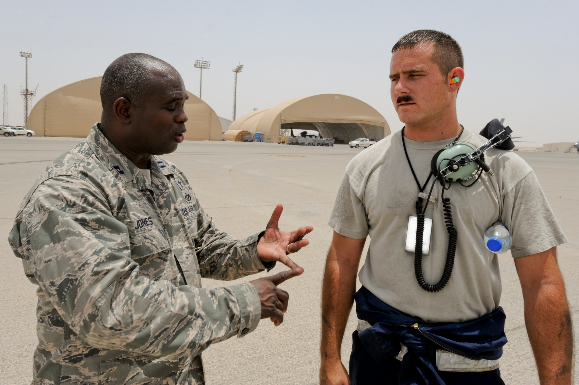 U.S. Air Force Chaplain (Capt.) Winston Jones, 380th Air Expeditionary Wing, talks with U.S. Air Force Staff Sgt. Jeffrey Bauer, 380th Expeditionary Aircraft Maintenance Squadron E-3 Sentry crew chief, during a visit to the flightline at an undisclosed location in Southwest Asia July 9, 2013. Jones is the maintenance and operation group's chaplain and visits Airmen on the flight line multiple times a week. Jones hails from Detroit, Mich., and is deployed from Joint Base Charleston, S.C. Bauer is native to St. Louis, Mo., and is deployed from Tinker Air Force Base, Okla. (U.S. Air Force photo by Staff Sgt. Joshua J. Garcia)