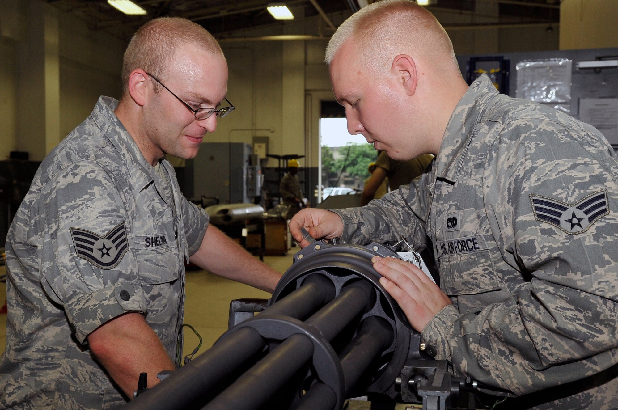 U.S. Air Force Staff Sgt. Dan Sheltrown, 35th Maintenance Squadron aircraft armament  craftsman, and Senior Airman Tyler Scoville, 35 MXS  aircraft armament journeyman, use a go no go gauge to measure the gap between the ammunition and the firing pin on a gattling gun at Misawa Air Base, Japan, July 11, 2013. The gun fires high explosive-incendiary 20mm bullets at a rate of 100 rounds per second. (U.S. Air Force photo by Airman 1st Class Zachary Kee)