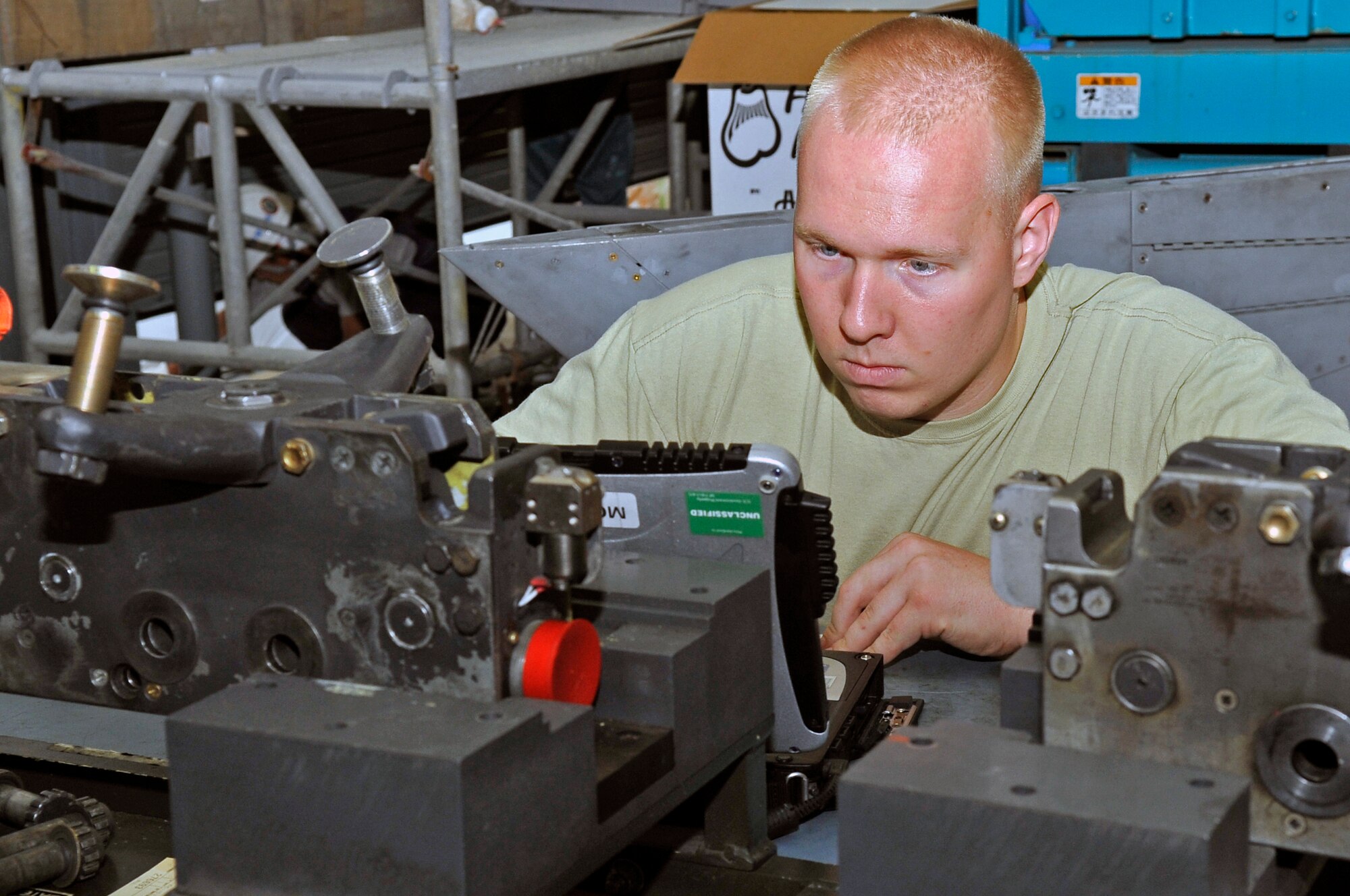 U.S. Air Force Senior Airman Tyler Scoville, 35th Maintenance Squadron aircraft armament journeyman, looks at his technical order while doing repairs at Misawa Air Base, Japan, July 11, 2013. Maintainers of the 35 MXS armament flight use technical orders to ensure they are doing everything correctly and reduce the likelihood of mistakes. (U.S. Air Force photo by Airman 1st Class Zachary Kee)