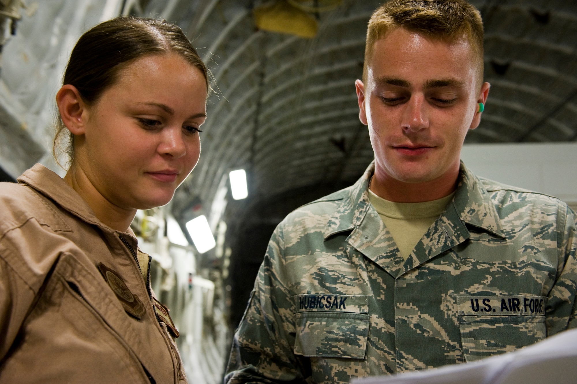 Staff Sgt. John Hubicsak discusses load plans with Airman 1st Class Brittany McGarrity on a C-17 Globemaster III at the 379th Air Expeditionary Wing in Southwest Asia, July 12, 2013. Hubicsak is an 8th Expeditionary Air Mobility Squadron air terminal operations center information controller deployed from Ramstein Air Base, Germany, and McGarrity is an 816th Expeditionary Airlift Squadron C-17 loadmaster deployed from Joint Base Charleston, S.C. (U.S. Air Force photo/Senior Airman Benjamin Stratton)