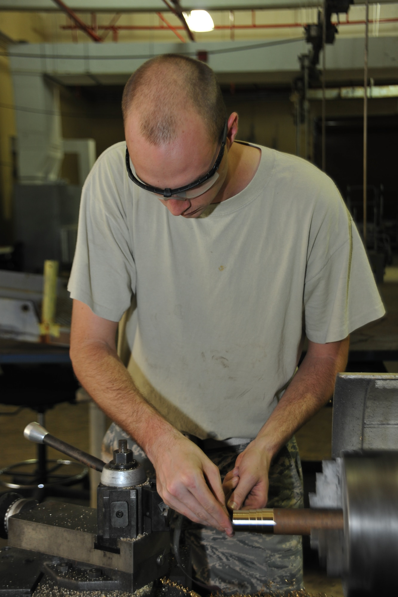 Staff Sgt. Jeremy Flint, 36th Maintenance Squadron Metals Technology Section NCO in charge, works on a lathe to manufacture aircraft components July 10, 2013, on Andersen Air Force Base, Guam. The metal technology section provides welding, precision measurement and machining to aircraft components and aircraft ground equipment. (U.S. Air Force photo by Senior Airman Robert Hicks/Released)