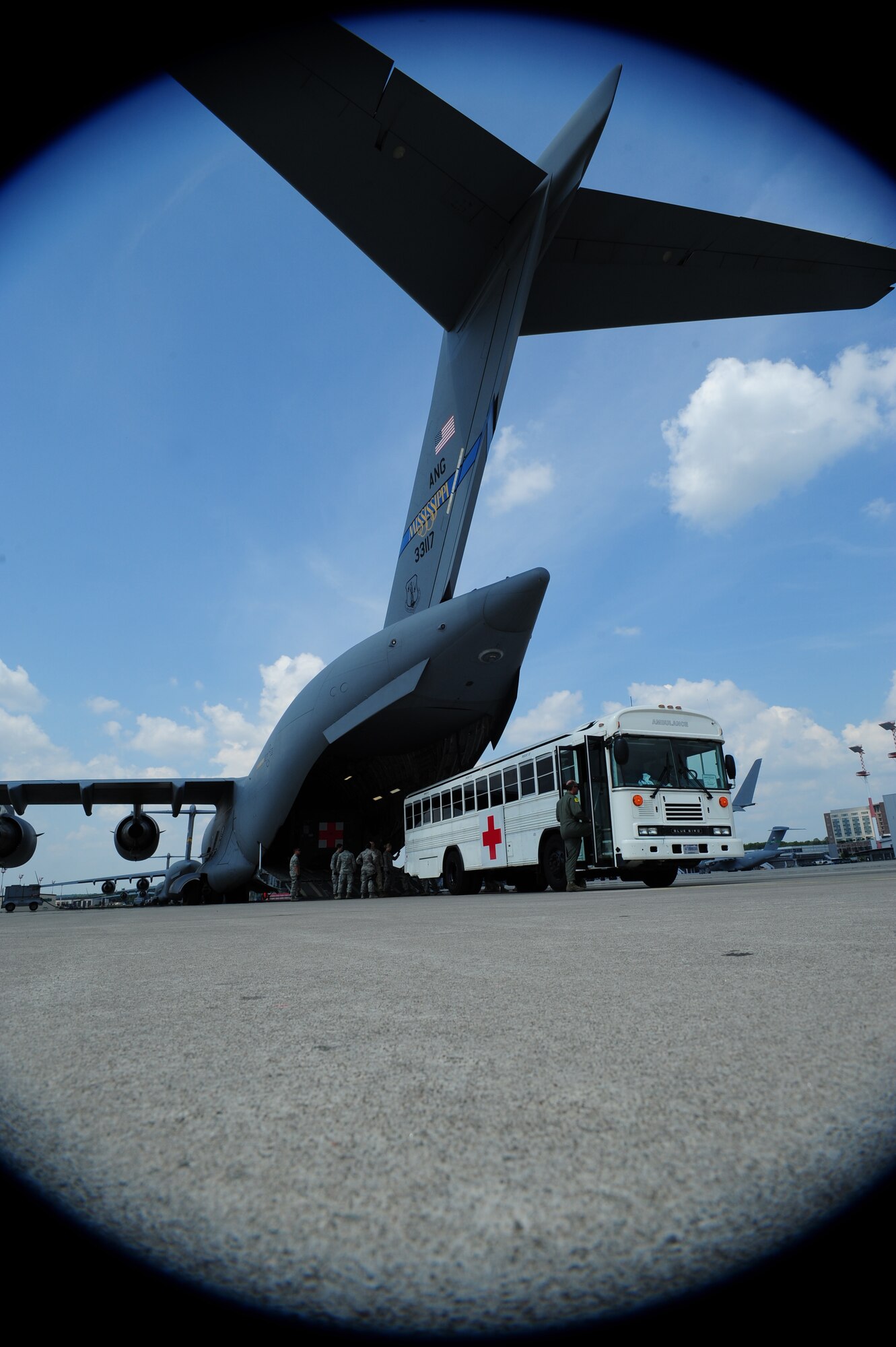 Service members wait outside a C-17 Globemaster III to assist in transferring a patient, July 10, 2013, Ramstein Air Base, Germany. An active duty Air Force crew made history while flying specialized medical teams and their patient requiring medical equipment never before used on board a Transatlantic mission. (U.S. Air Force photo/Senior Airman Hailey Haux)