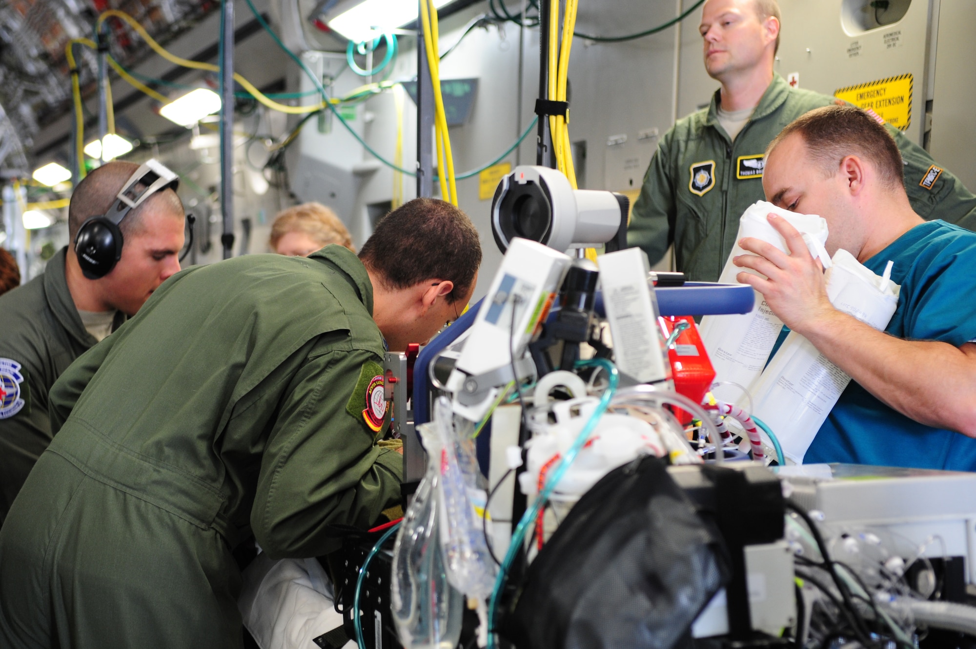 A specialized medical team ensures a patient is safe and ready for takeoff, July 10, 2013, Ramstein Air Base, Germany. An active duty Air Force crew made history while flying specialized medical teams and their patient requiring medical equipment never before used on board a Transatlantic mission. (U.S. Air Force photo/Senior Airman Hailey Haux)