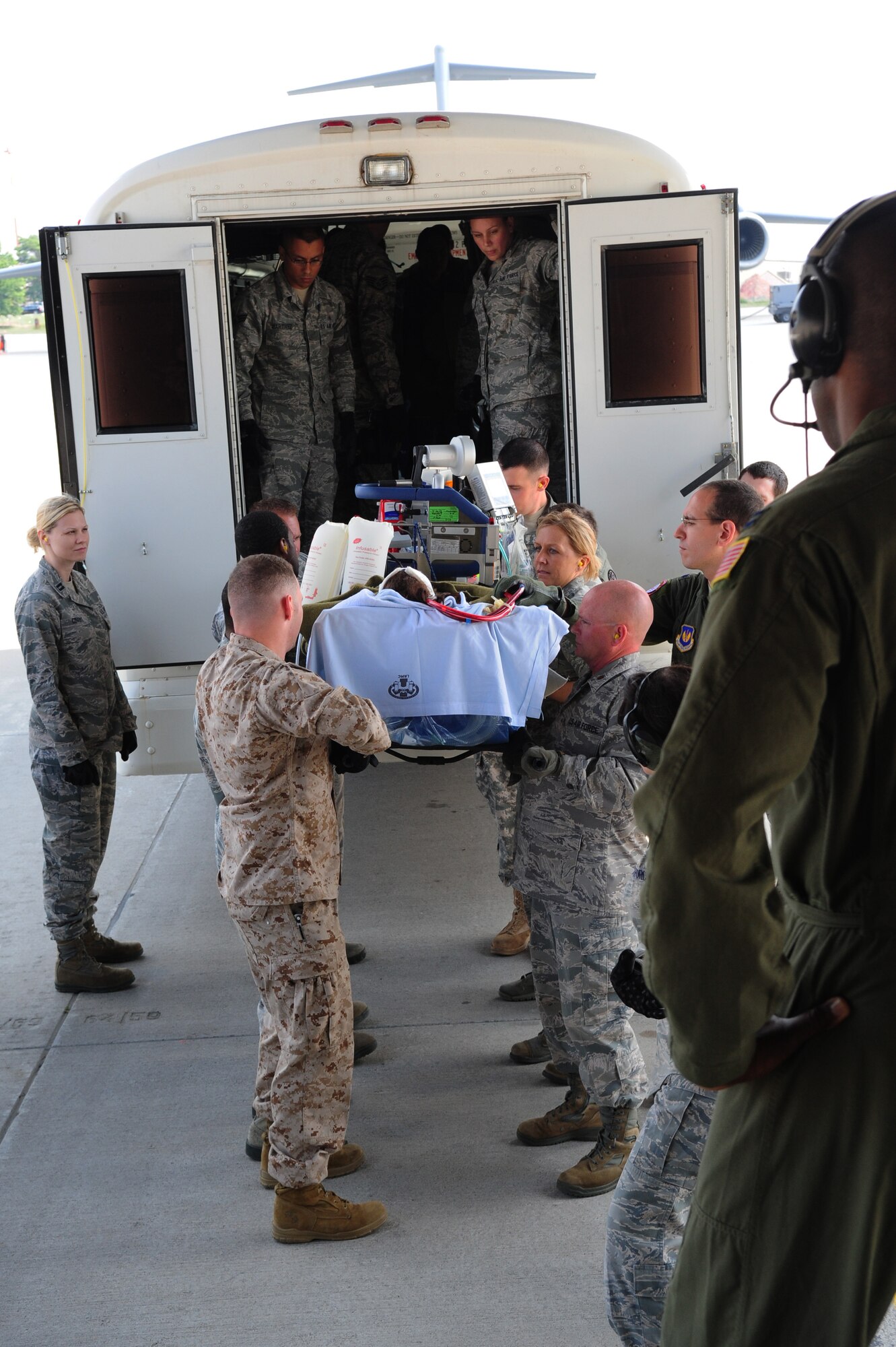 Service members work together to transfer a patient aboard a C-17 Globemaster III, July 10, 2013, Ramstein Air Base, Germany. An active duty Air Force crew made history while flying specialized medical teams and their patient requiring medical equipment never before used on board a Transatlantic mission. (U.S. Air Force photo/Senior Airman Hailey Haux)