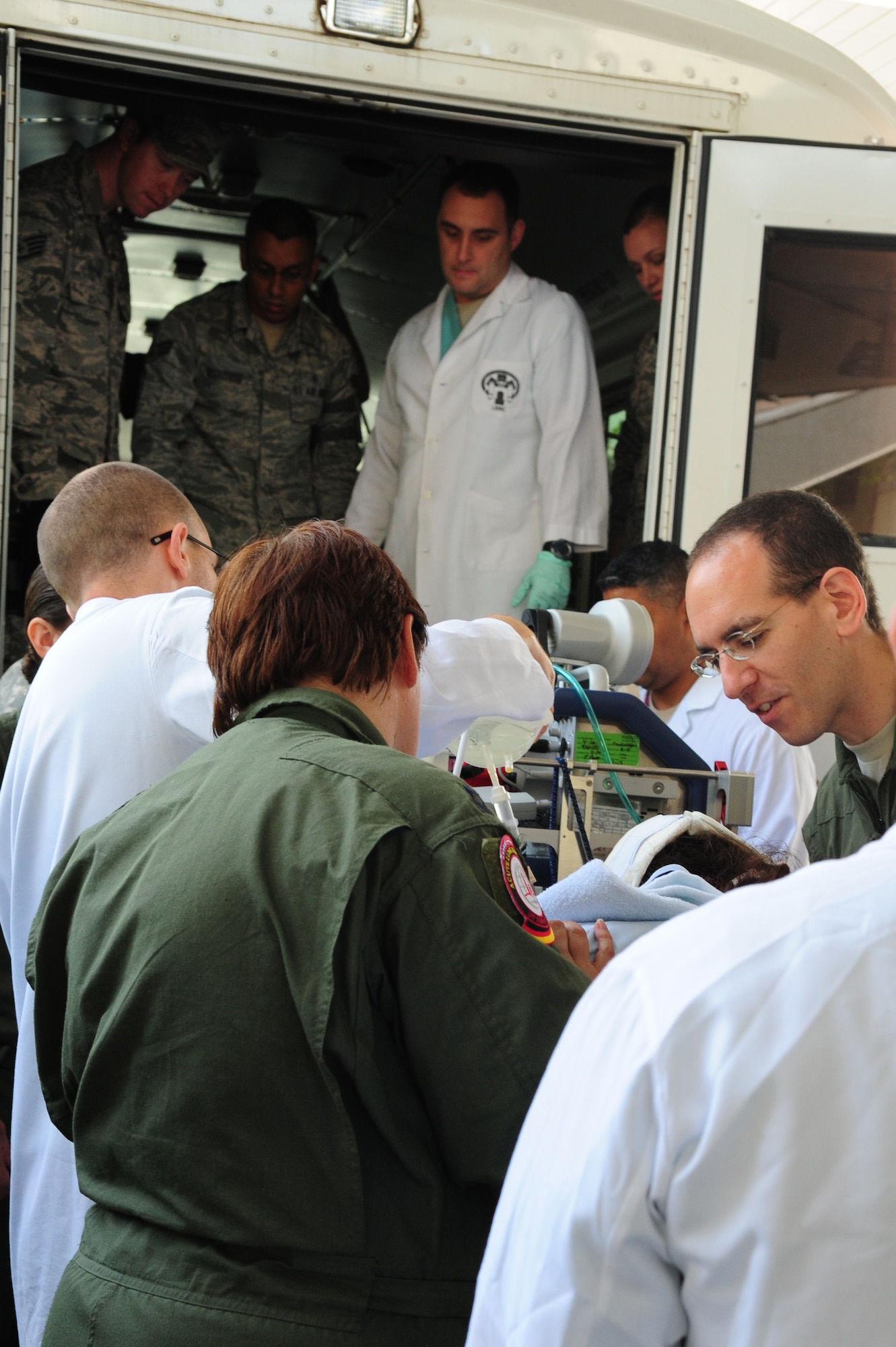 Service members work together to transfer a patient onto a medical bus, July 10, 2013, Landstuhl Regional Medical Center, Germany. An active duty Air Force crew made history while flying specialized medical teams and their patient requiring medical equipment never before used on board a Transatlantic mission. (U.S. Air Force photo/Senior Airman Hailey Haux)