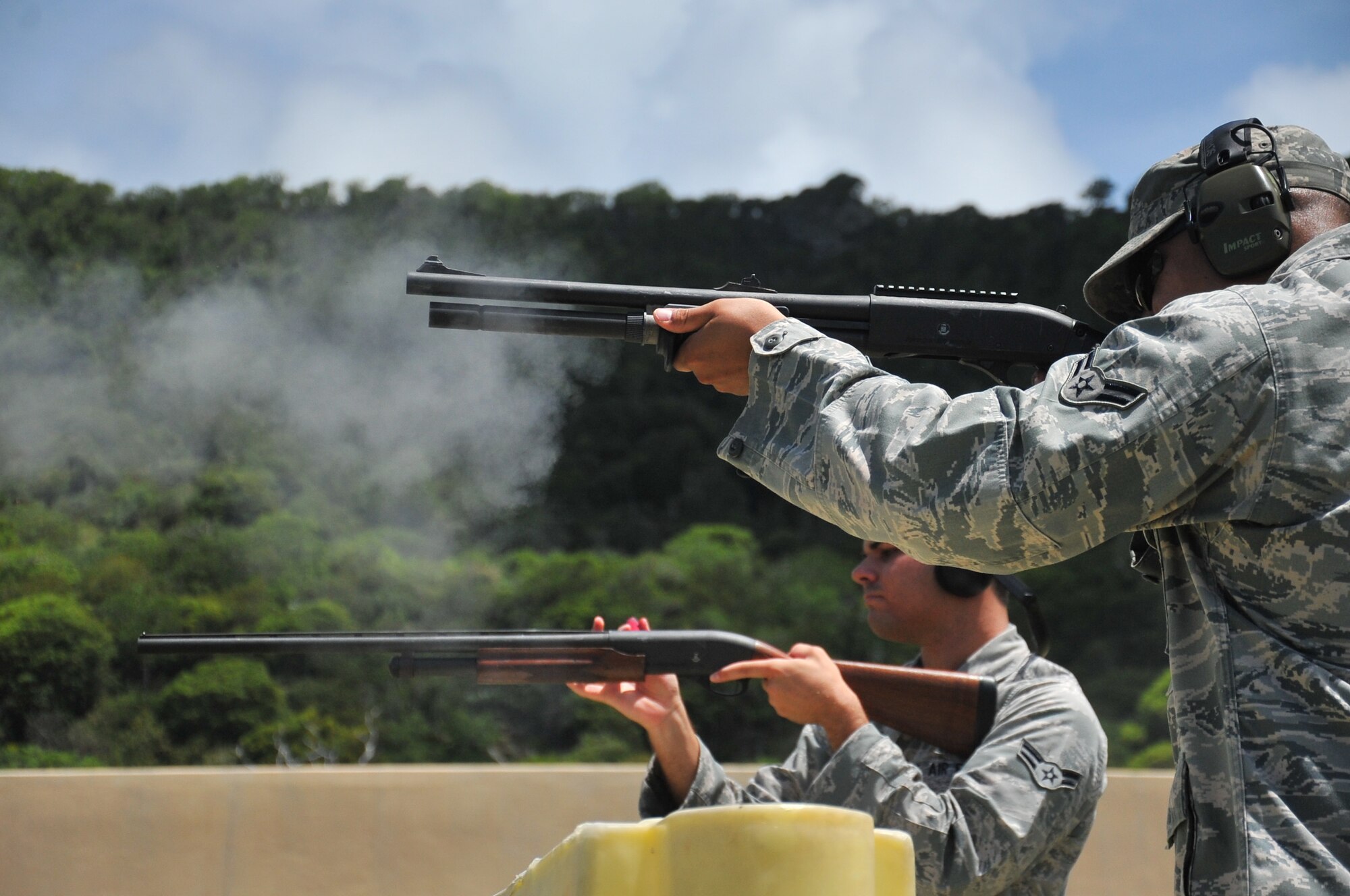 Airman 1st Class Dennis Schoonmaker, 36th Security Forces Squadron patrolman (right), and Airman 1st Class Mauricio Perez, left, 36th Operations Support Squadron Airfield Management shift lead, fire downrange at the Combat Arms Training and Maintenance range on Andersen Air Force Base, Guam, July 10, 2013. The CATM mission is to ensure all weapons utilized by 36th Wing personnel are functional, maintained and ready when the Airmen are called to duty. (U.S. Air Force photo by Airman 1st Class Adarius Petty/Released))