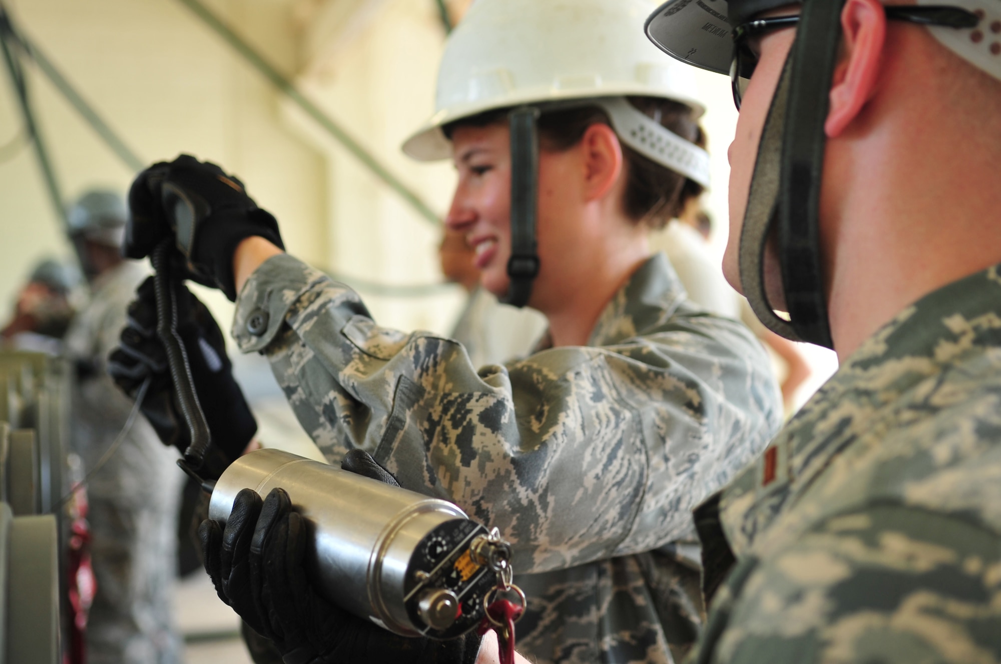U.S. Air Force 2nd Lt. Daniel Stone, 18th Munitions Squadron materiel flight commander, assists 2nd Lt. Virginia Nord, 18th Logistics Readiness Squadron aviation support officer in charge, with a fuse for a GBU-32  munition during a bomb-building demonstration on Kadena Air Base, Japan, July 9, 2013. In an effort for young logistics leaders to gain a better understanding of the 18th MUNS, members from the Logistics Officer Association had the opportunity to tour the squadron and built guided bombs. (U.S. Air Force photo by Senior Airman Amber E. N. Jacobs/Released)