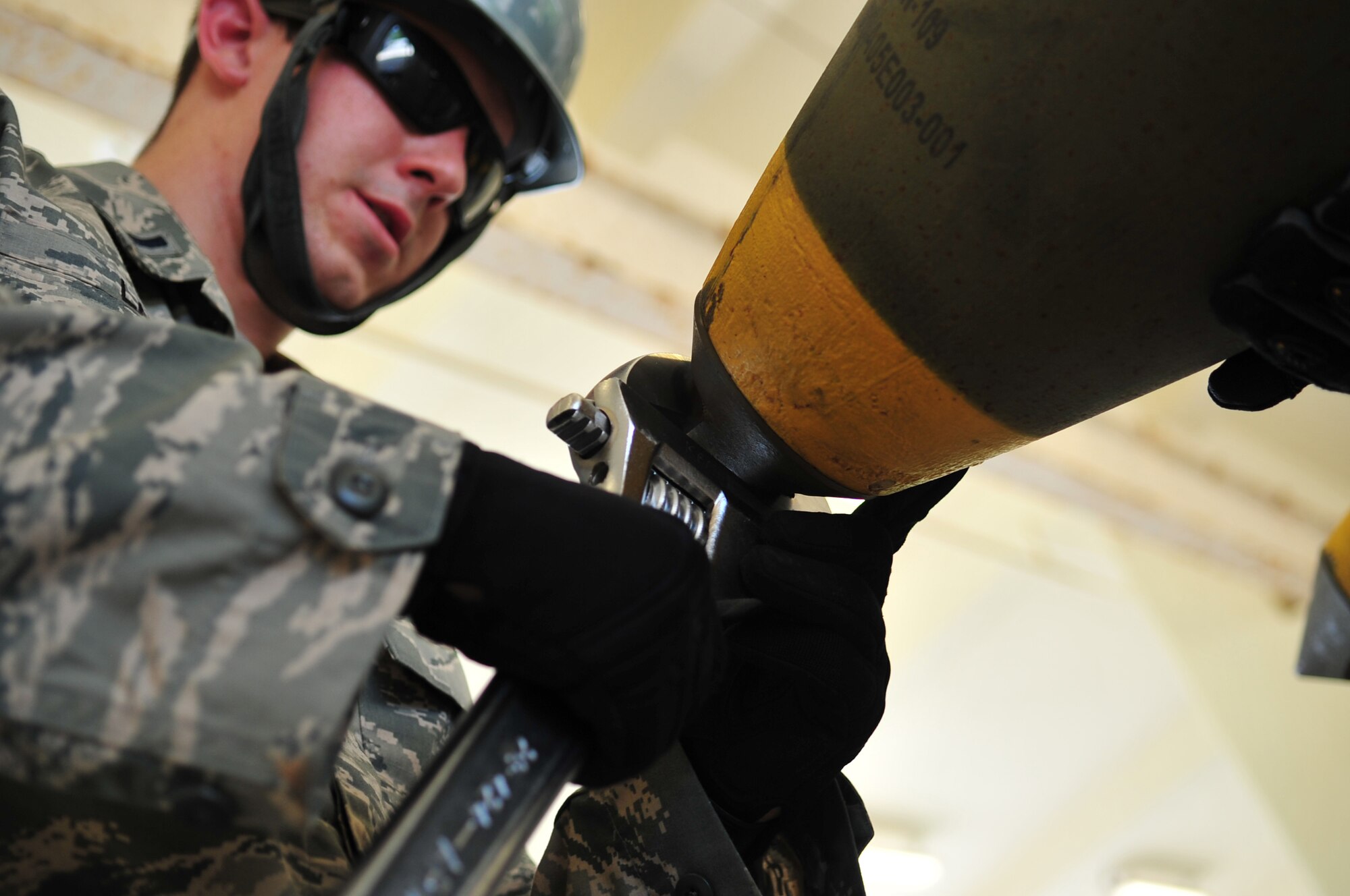 U.S. Air Force 1st Lt. Steven Lane, 733rd Air Mobility Squadron passenger service officer in charge, tightens a cap on a GBU-32 munition during a bomb-building demonstration on Kadena Air Base, Japan, July 9, 2013. Lane was one of four members from the Logistics Officer Association who toured the 18th Munitions Squadron in an effort to gain a better understanding of the squadron. (U.S. Air Force photo by Senior Airman Amber E. N. Jacobs/Released)