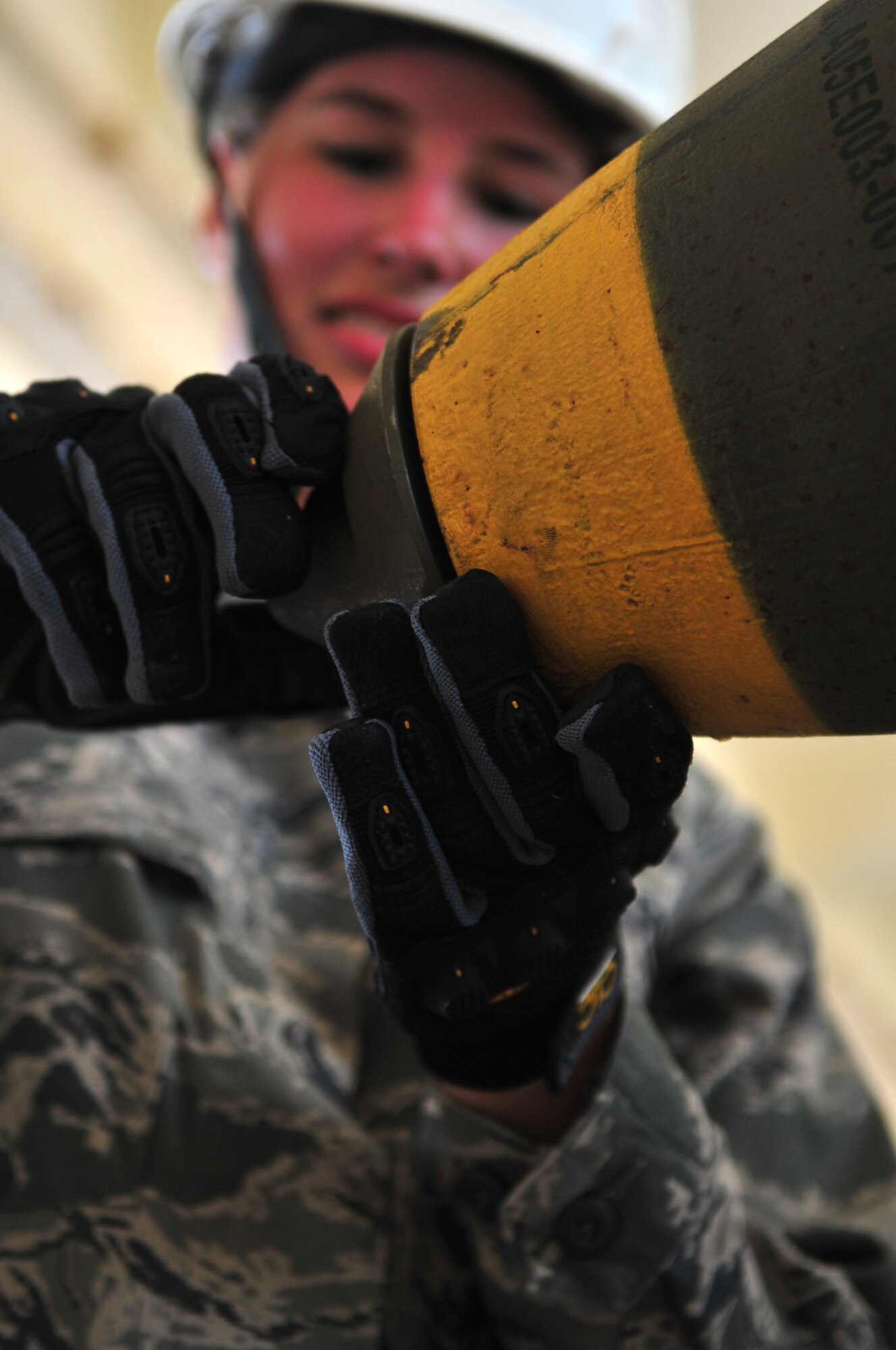 U.S. Air Force 2nd Lt. Virginia Nord, 18th Logistics Readiness Squadron aviation support officer in charge, tightens a cap on a GBU-32 munition on Kadena Air Base, Japan, July 9, 2013. Members from the Logistics Officer Association toured the 18th Munitions Squadron and had an opportunity to build guided bombs for F-22 Raptor aircraft in an effort to gain a better understanding of the role and responsibilities of the squadron. (U.S. Air Force photo by Senior Airman Amber E. N. Jacobs/Released)