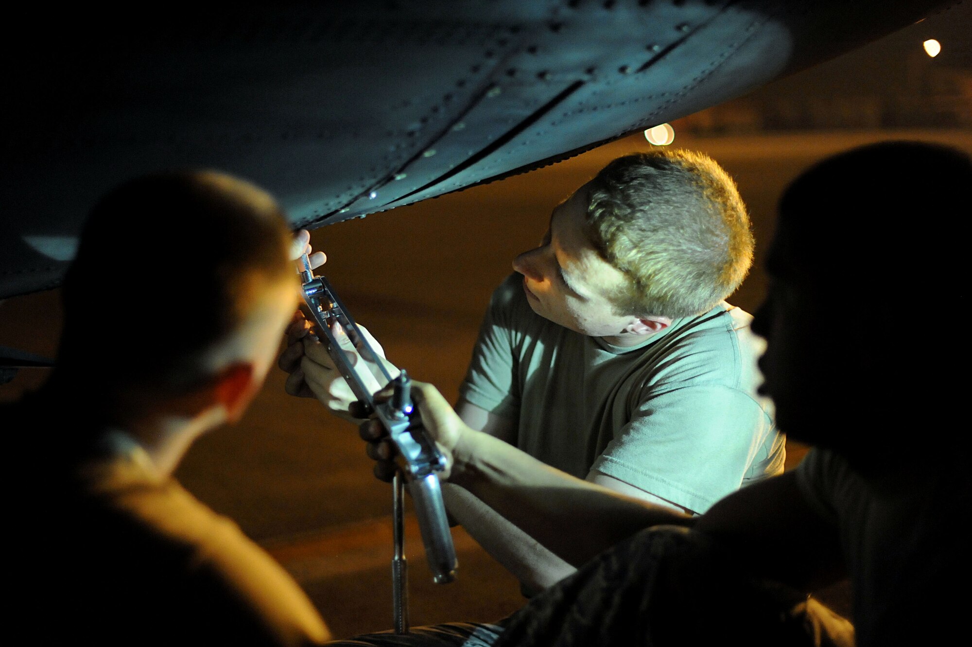 YOKOTA AIR BASE, Japan -- Crew chiefs from the 374th Aircraft Maintenance Squadron work to removing a panel on a C-130 Hercules on July 10, 2013 at Yokota Air Base, Japan.  Each aircraft gets its own group of crew chiefs to inspect and check it every night.  (U.S. Air Force photo by Airman 1st Class Meagan Schutter)