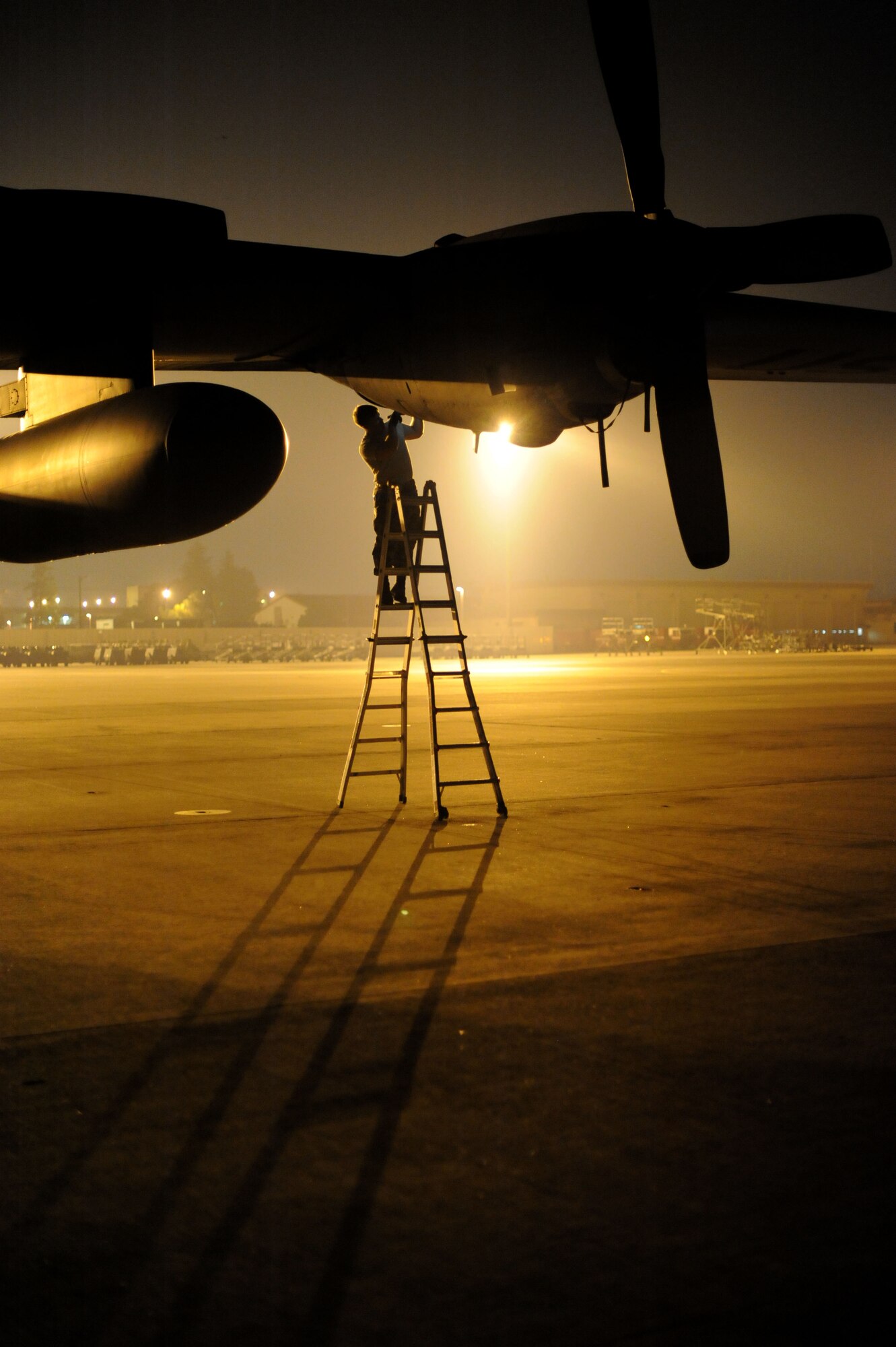 YOKOTA AIR BASE, Japan -- Staff Sgt. Andrew Dittman, 374th Aircraft Maintenance Squadron crew chief, works on a C-130 Hercules on July 10, 2013 at Yokota Air Base, Japan.  Crew chiefs are assigned to specific planes each night to perform routine maintenance. (U.S. Air Force photo by Airman 1st Class Meagan Schutter)