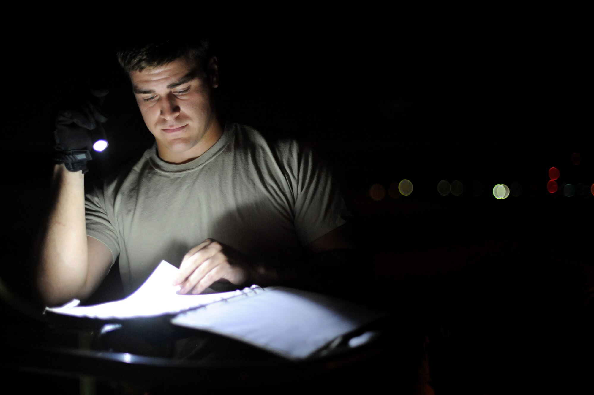 YOKOTA AIR BASE, Japan -- Staff Sgt. Andrew Dittman, 374th Aircraft Maintenance Squadron crew chief, checks over work forms before working on a C-130 Hercules on July 10, 2013 at Yokota Air Base, Japan.  Crew chiefs are assigned to specific planes each night to perform routine maintenance. (U.S. Air Force photo by Airman 1st Class Meagan Schutter)