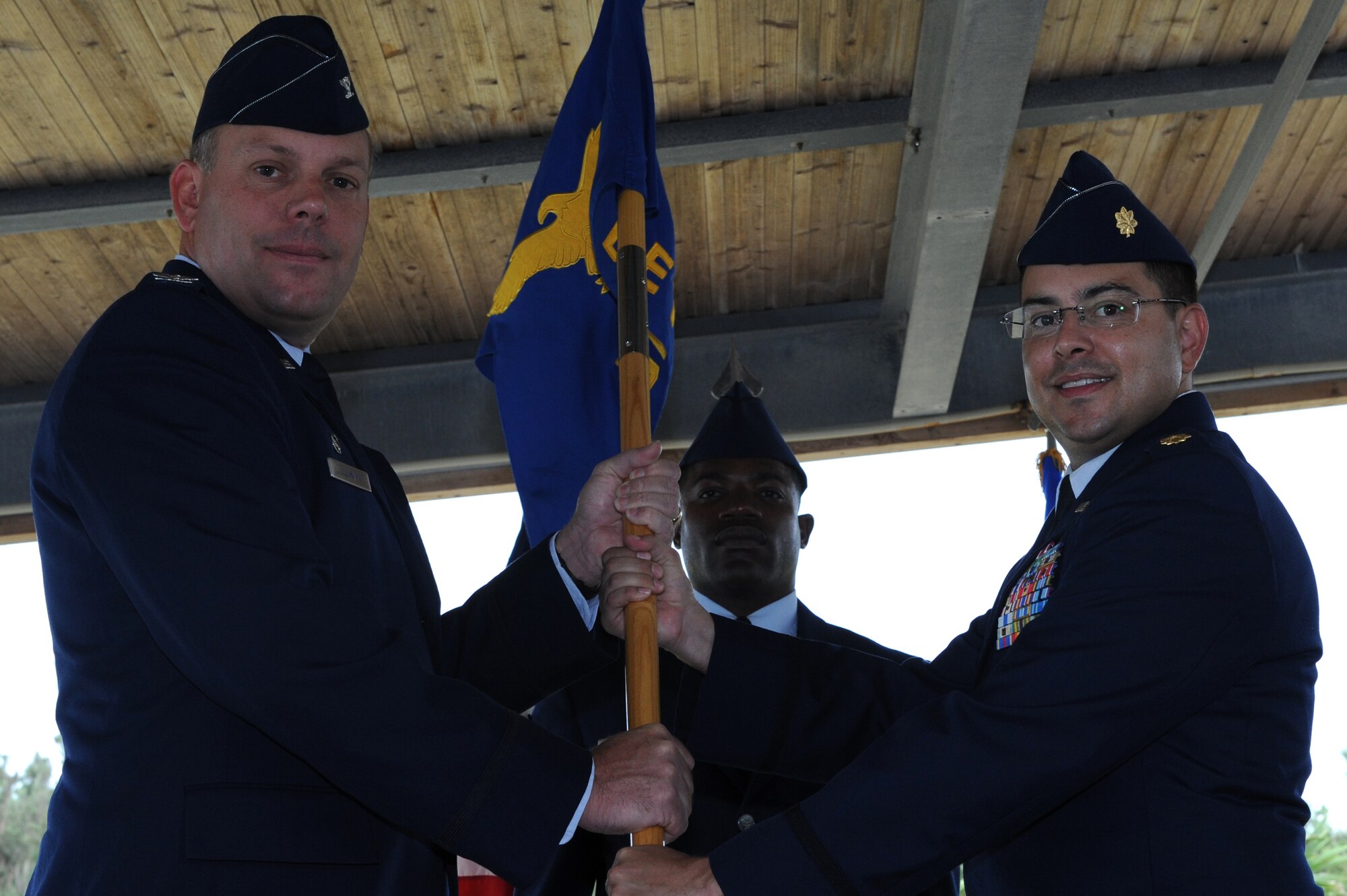U.S. Air Force Col. Jeff Ullmann, 18th Mission Support Group commander, passes the guidon to Maj. Robert Tarantino, Det. 1, 18th Force Support Squadron commander, at the Okuma Recreation Facility on Okinawa, Japan, July 12, 2013. The Okuma Recreation Facility is a 135-acre outdoor recreation area hosting more than 80,000 joint service and Department of Defense civilian guests annually. Tarantino leads nine military personnel from five different Air Force Specialty Codes, three U.S. civilians and more than 100 local nationals across eight diverse activities, controlling a $750,000 operating budget and capital assets. (U.S. Air Force photo by Airman 1st Class Hailey R. Davis/Released)