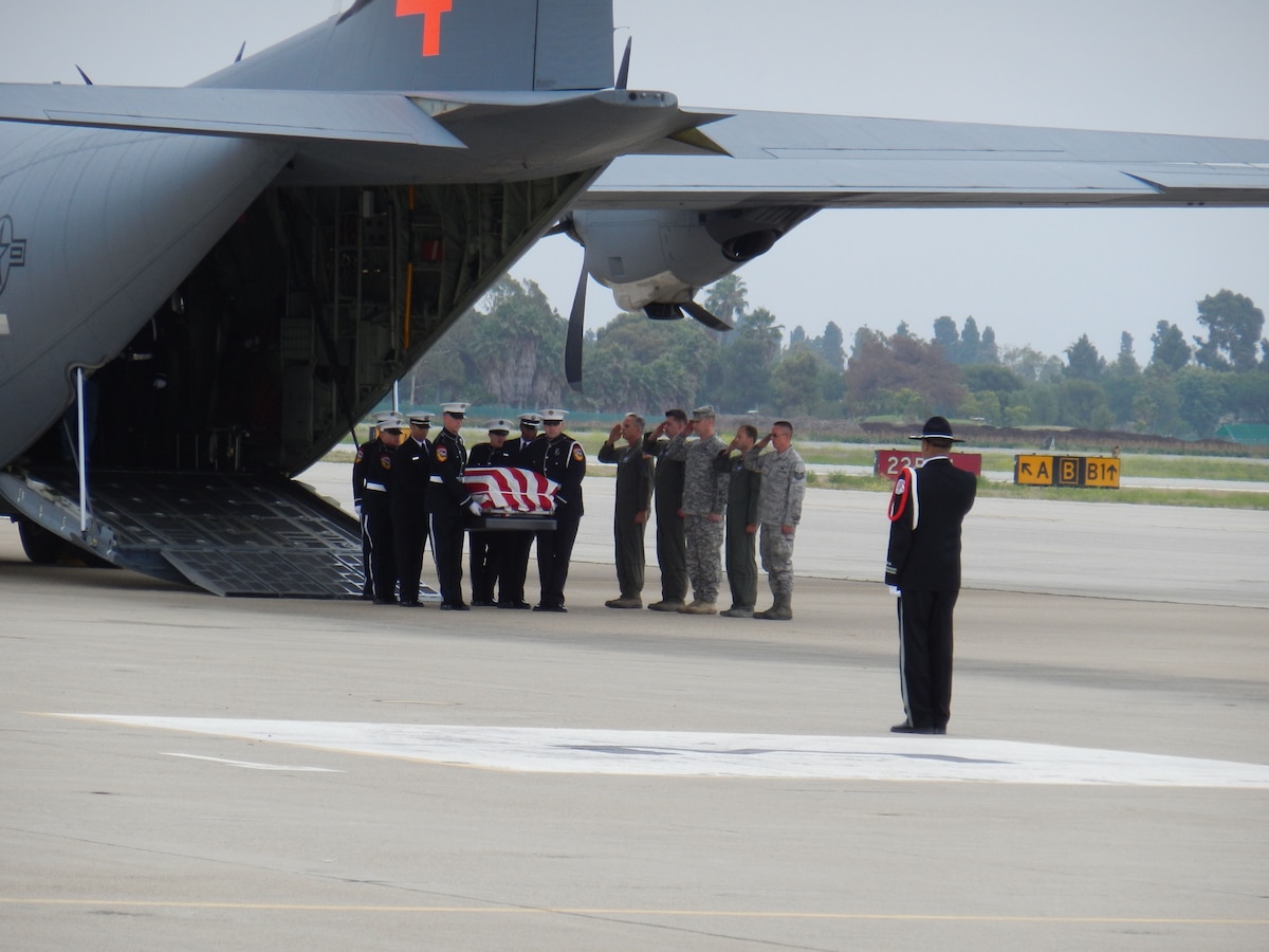 Colonel Paul Hargrove and air crew members from the 146th Airlift Wing salute as brethren firefighters serving as honor guard carry the bodies of Christopher Mackenzie age 30 and Kevin Woyjeck age 21 from the back of a C130-J aircraft stati...oned at Channel Islands Air National Guard Station. After getting approval from the Secretary of Defense, the 146th served as transport for these California natives to return home. The two men were killed last week working as a firefighting hotshot crew battling the Yarnell fire in Prescott, Arizona. (U.S. Air Force photo by Maj. Kimberly Holman)
