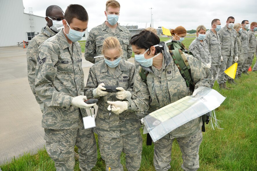 The remains recovery team combs the flight line and records the location of “human remains” from a simulated plane crash that took place as part of the Mass Accident Response Exercise, Niagara Falls International Air Port, June 8, 2013. (U.S. Air Force photo by Staff Sgt. Stephanie Clark) 