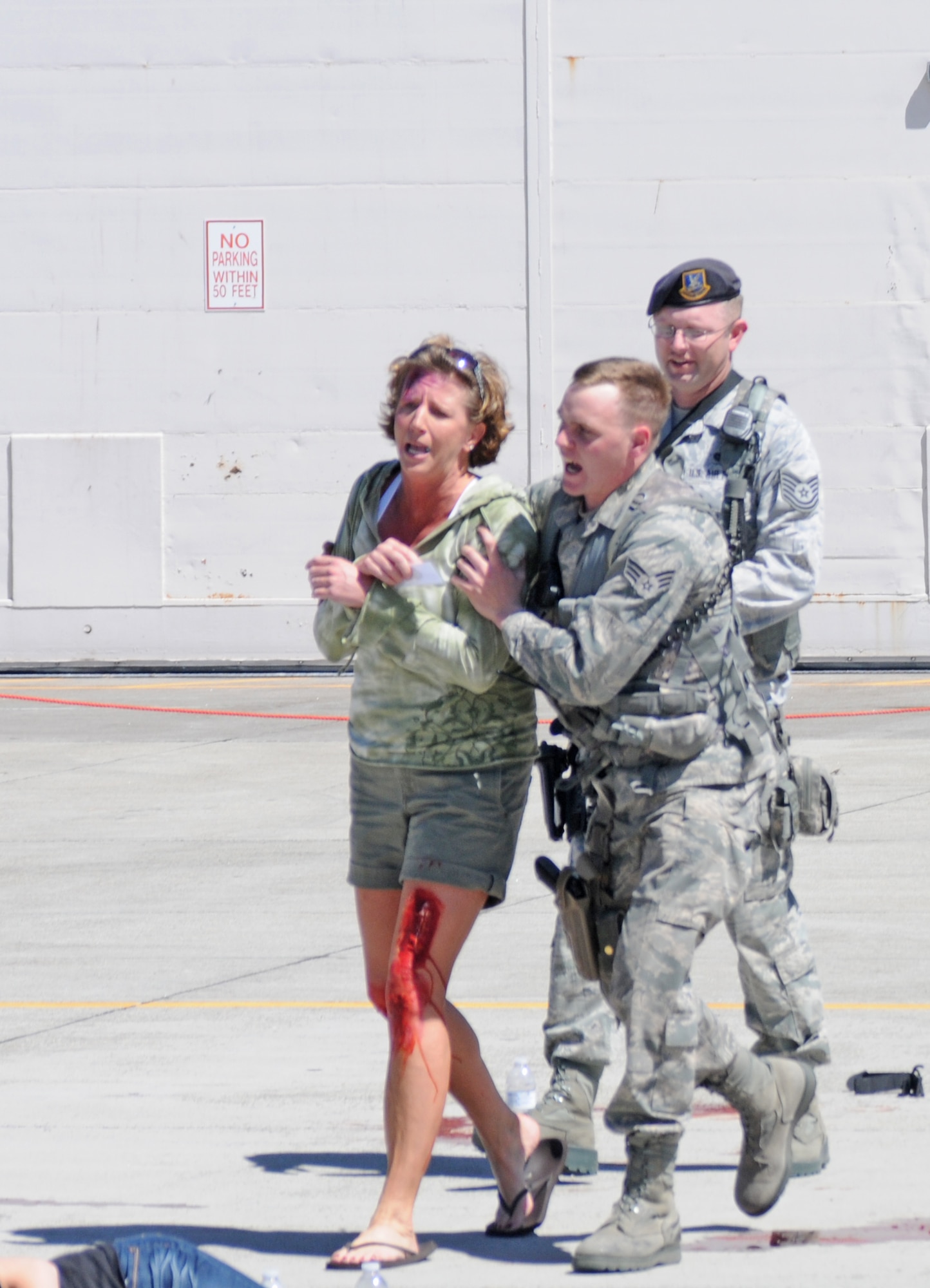 Members of the 173rd Fighter Wing Security Forces Squadron detain a moulaged hysterical individual assists during a major accident response exercise at Kingsley Field, Klamath Falls, Ore. June 1, 2013.   Volunteers from the local community assist with the exercise by playing the role of the wounded.  (Air National Guard photo by Master Sgt. Jennifer Shirar)  