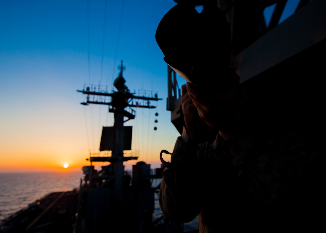 U.S. Marine Corps Cpl. Kyle Runnels, a 26th Marine Expeditionary Unit (MEU) combat correspondant, takes photos at sunset aboard the USS Kearsarge (LHD 3), at sea, July 13, 2013.  The 26th MEU is a Marine Air-Ground Task Force forward-deployed to the U.S. 5th Fleet area of responsibility aboard the Kearsarge Amphibious Ready Group serving as a sea-based, expeditionary crisis response force capable of conducting amphibious operations across the full  range of military operations. (U.S. Marine Corps photo by Sgt. Christopher Q. Stone/Released)