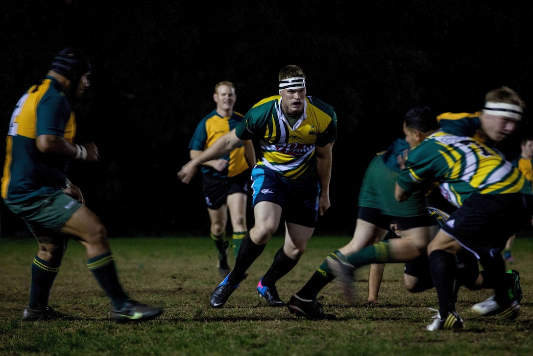 Sergeant Rian D. O’Shea (center), a chemical, biological, radiological, and nuclear defense non-commissioned officer in charge for the 31st MEU, and a native of Eugene, Org., moves to support the tackle of a teammate during a rugby match against the Brisbane West Bulldogs here, July 12. The match was orchestrated weeks prior to the units’ arrival in Australia as a way for the service members to embrace some of the culture and build camaraderie. Over the next few weeks, the Marines and Sailors of the 31st MEU and the Amphibious Squadron 11 will conduct integrated training with their Australian counterparts in order to improve their cooperative ability to plan, communicate and conduct complex operations.