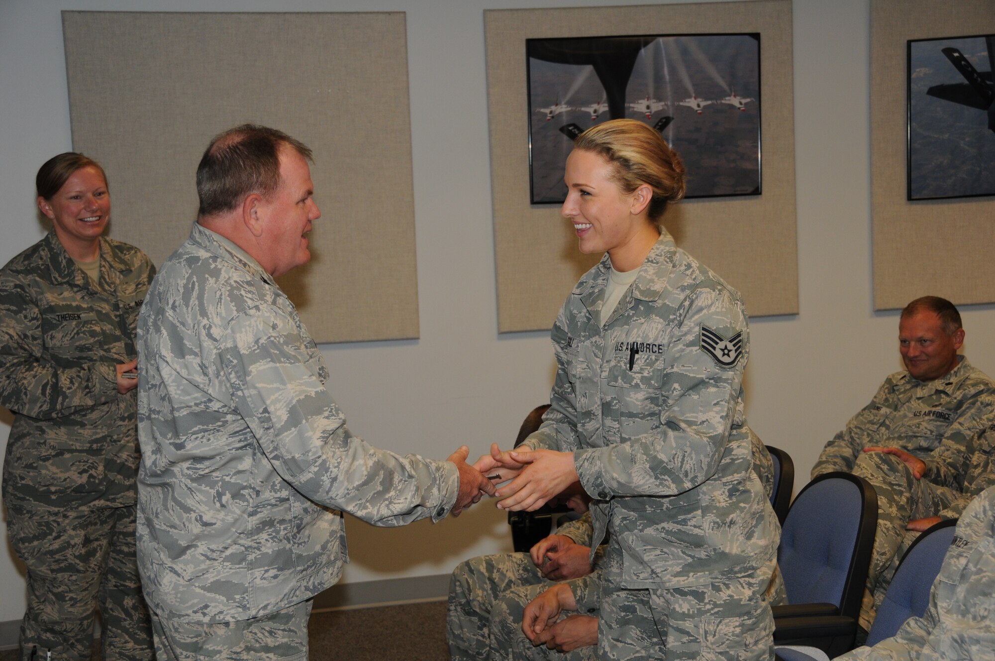 Staff Sgt. Keely Gill recieves a coin from Col. Brian Miller for scoring 100 percent on her 2012 fitness test at the 185th Air Refueling Wing Air Base in Sioux City, IA July 14, 2013. (U.S. Air Guard photo by 1LT Jeremy J. McClure/Released)