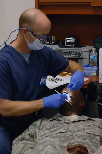 Tech. Sgt. Roy Simmons, 403rd Civil Engineer Squadron emergency manager, receives a dental exam from Dr. Wade Bishop, dentist, at the on-site dental clinic held in the 403rd Aeromedical Staging Squadron July 13, 2013.  The dental clinic took place to ensure deployment readiness of 403rd Wing members (U.S. Air Force photo/Tech. Sgt. Jessica L. Kendziorek).